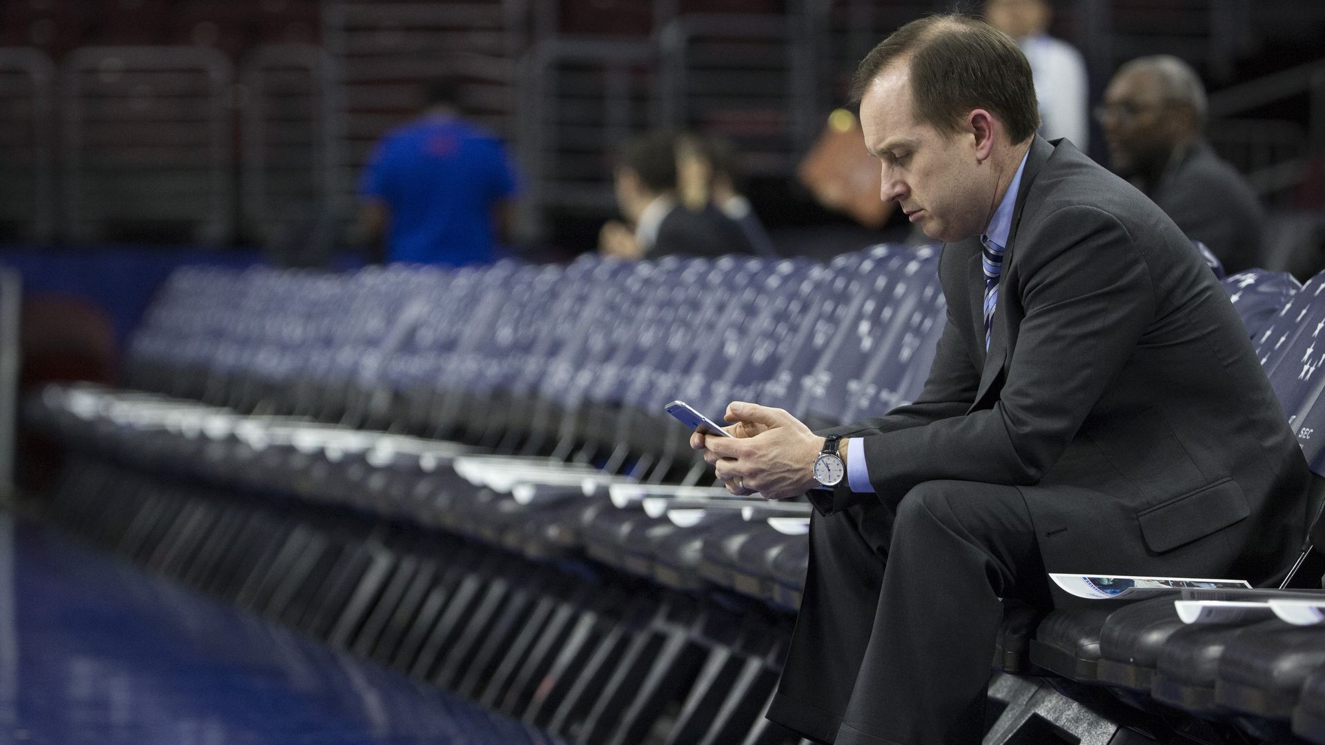 Sam Hinkie sitting next to a basketball court.