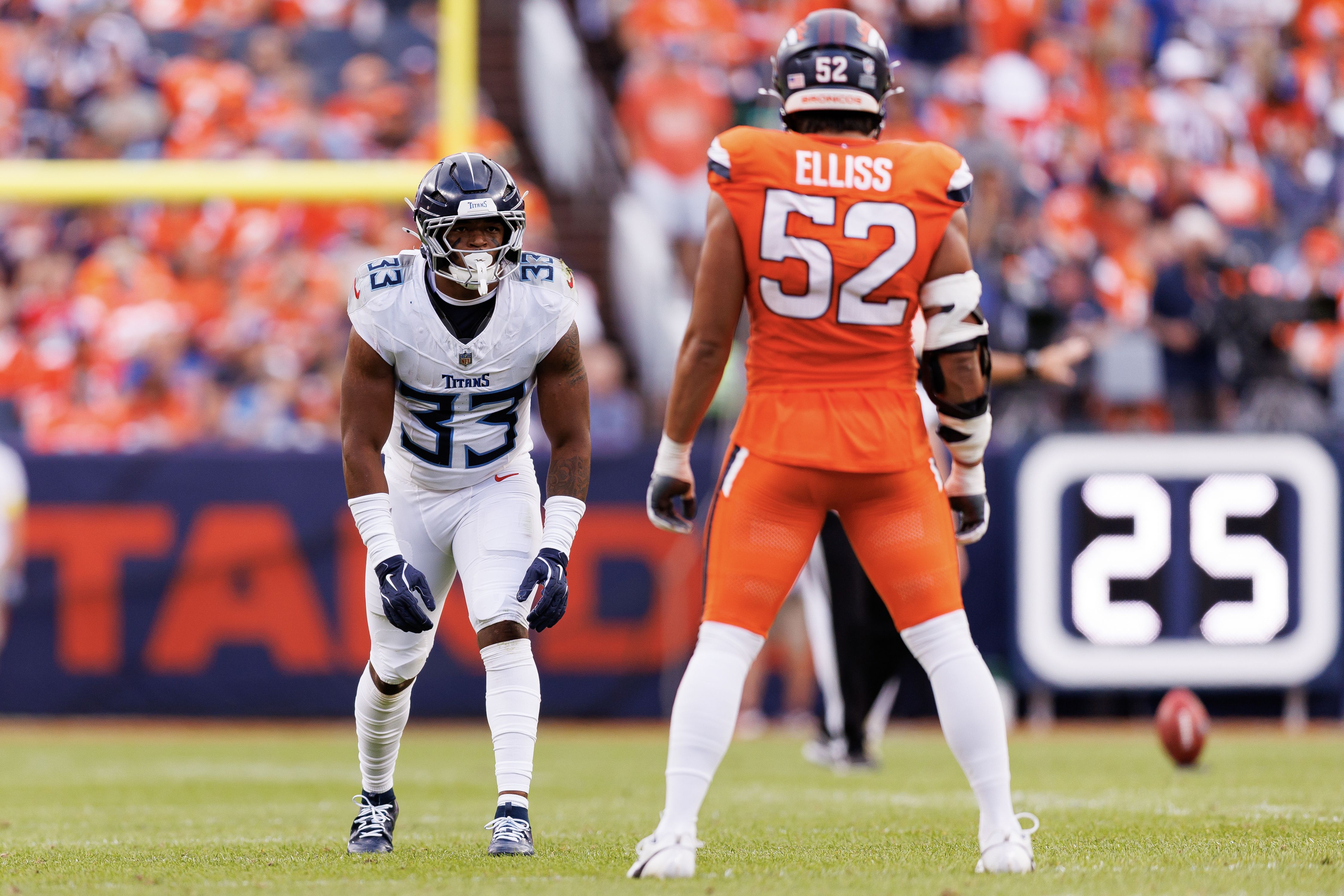 Cedric Gray #33 of the Tennessee Titans gets set during the first half of an NFL football game against the Denver Broncos. The Titans are in white uniforms. The Broncos are in orange uniforms.