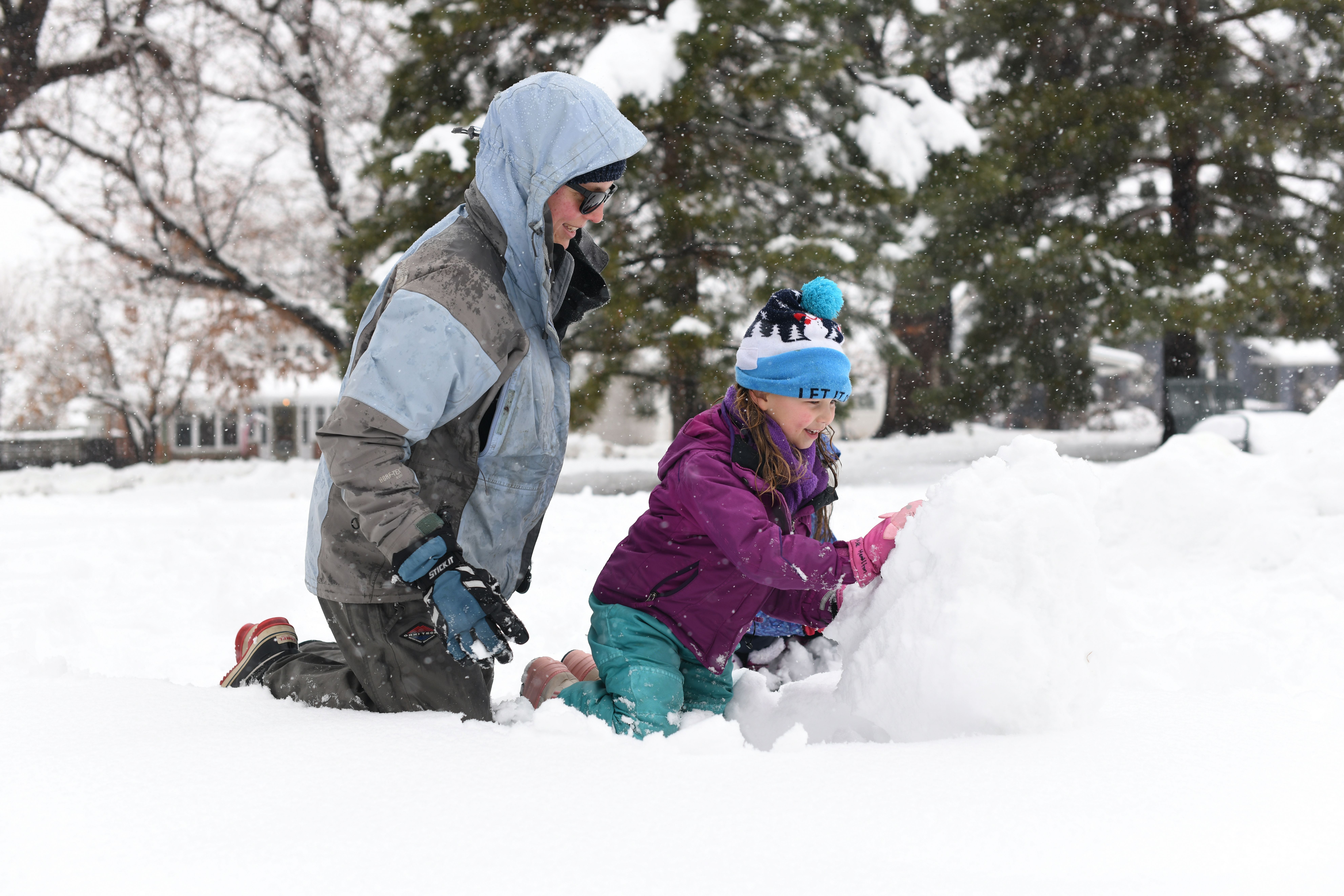 Alice Hamilton, 5, right, makes a snowman with her mother, Stephanie, at James H. Platt Park in Denver. Photo: Hyoung Chang/The Denver Post