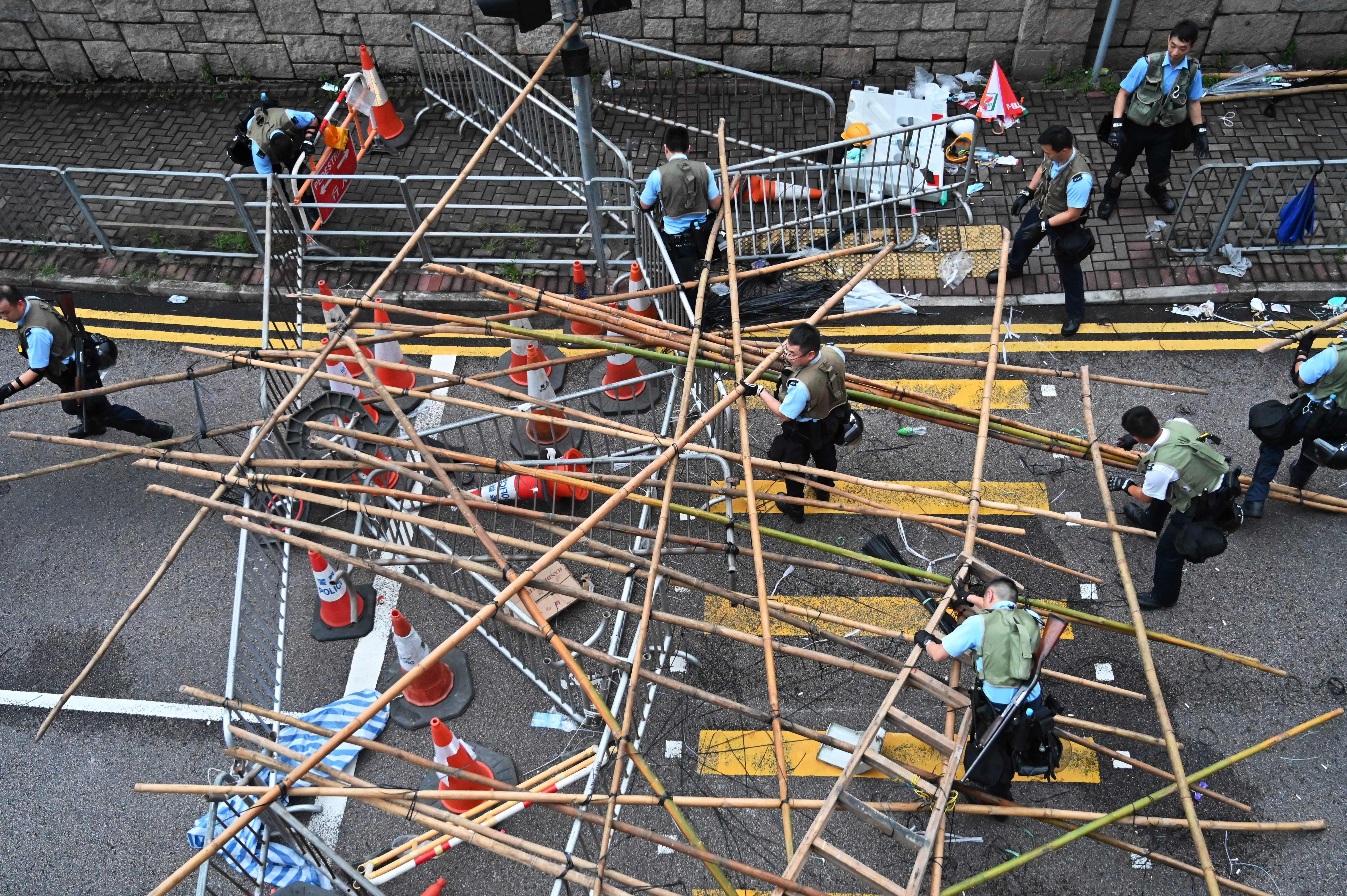 Police officers dissolve the barricades placed by demonstrators in Hong Kong on June 13, 2019. 