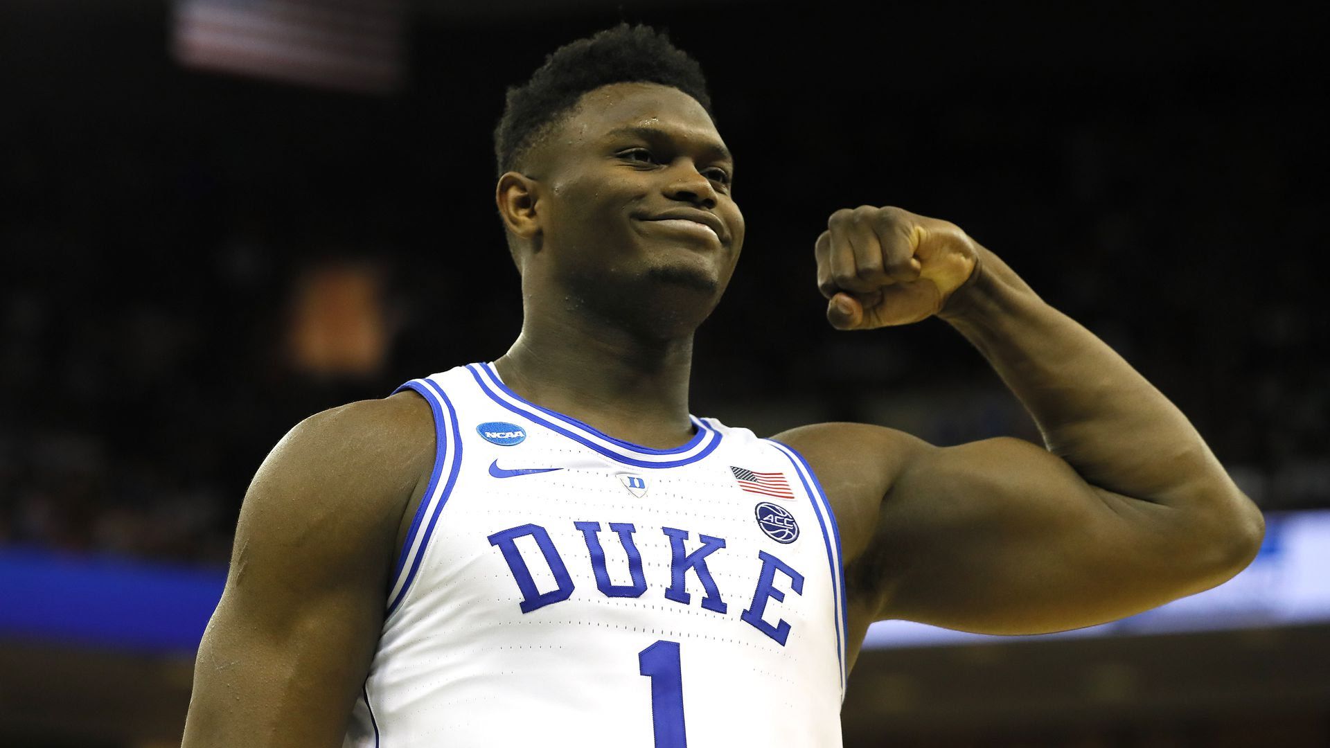 Zion Williamson in a Duke jersey as he flexes his arm 