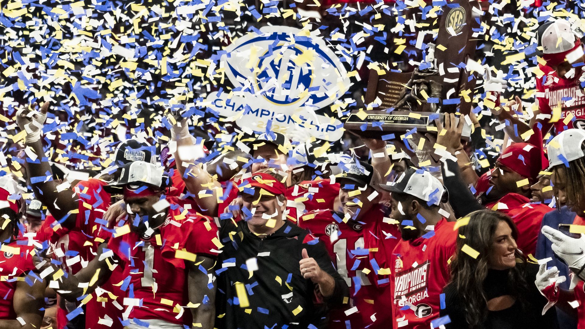 confetti falls around the Georgia Bulldogs as they hold up the SEC championship trophy