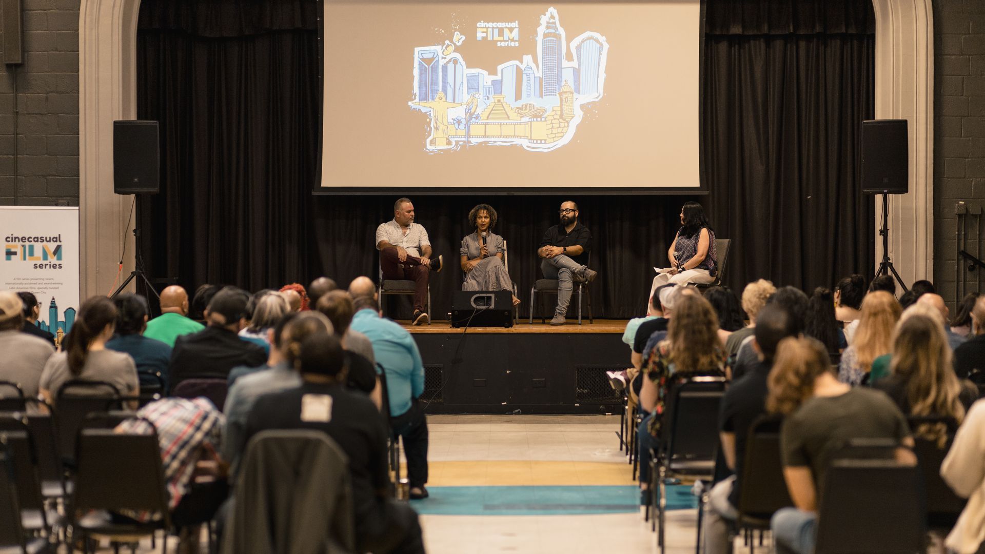 theater full of people watching a panel speak on stage