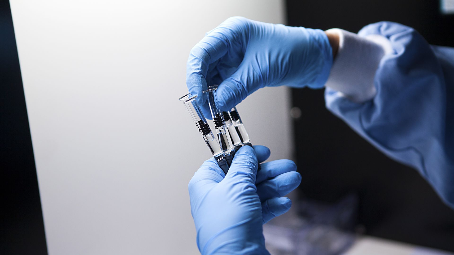 A person holds up injectable drugs in syringes.