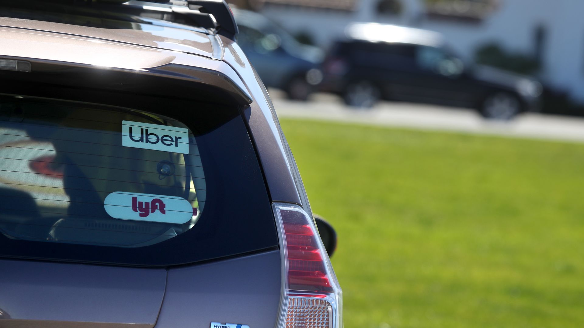 back of a car with the Uber and Lyft logos on the window