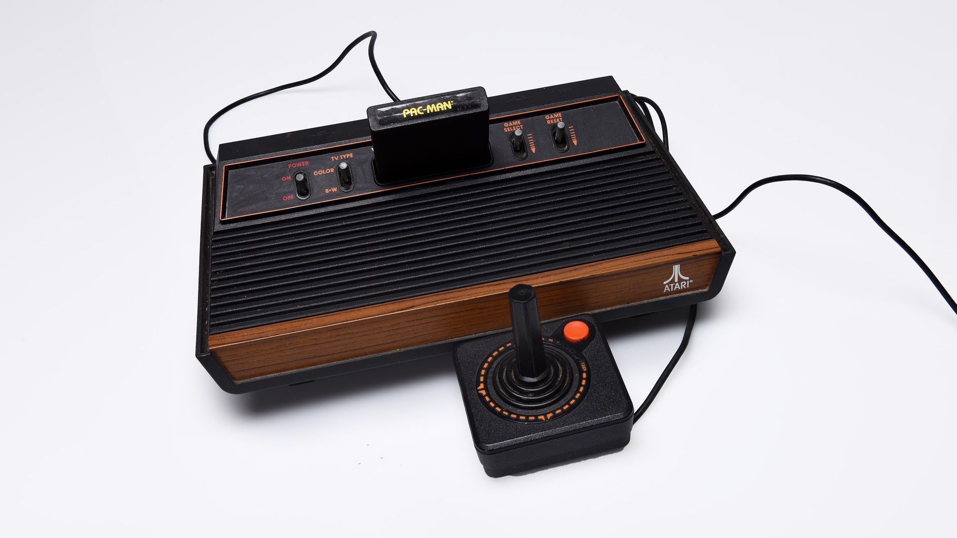 Black and brown video game console with a joystick controller attached