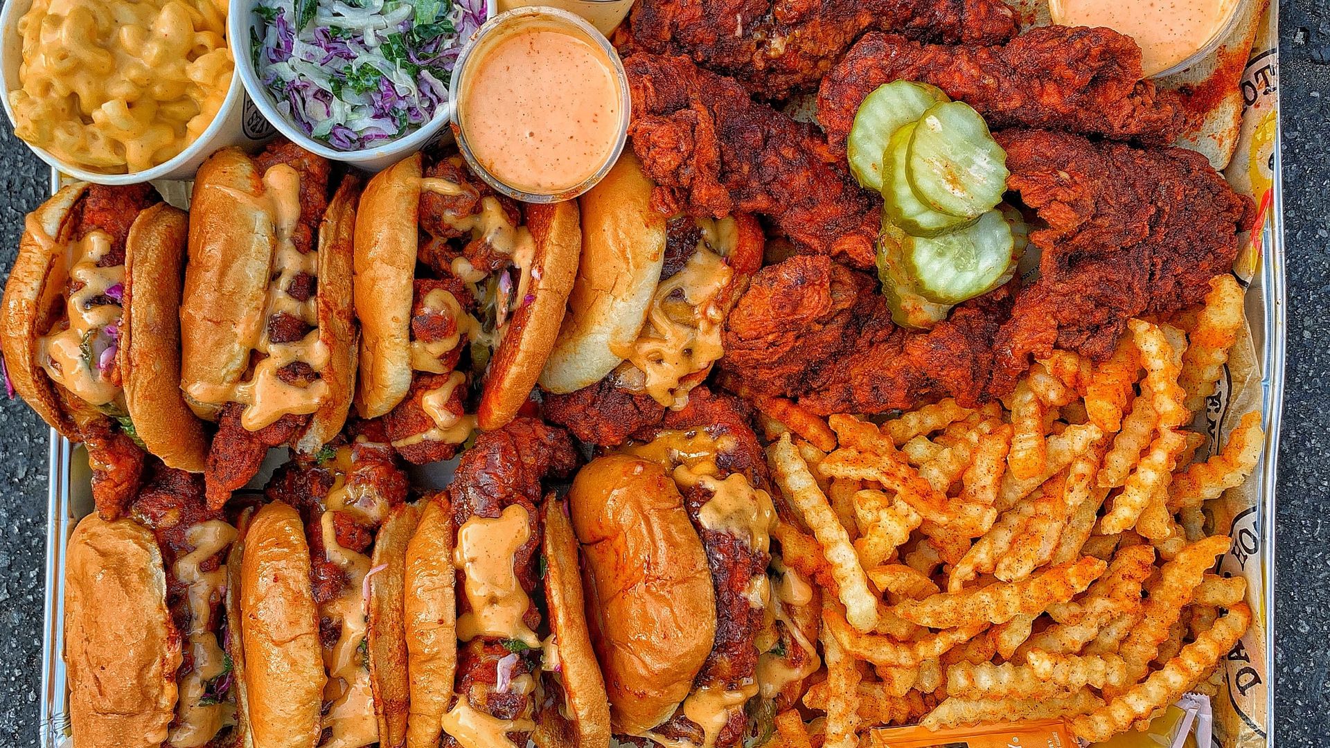 Assortment of Dave's Hot Chicken food including sandwiches, fries and tenders.