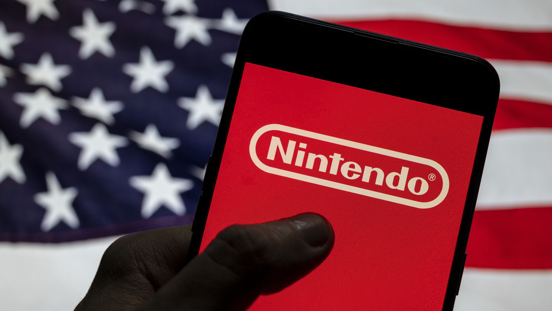 Photo of a phone with a Nintendo logo on it, held in front of an American flag