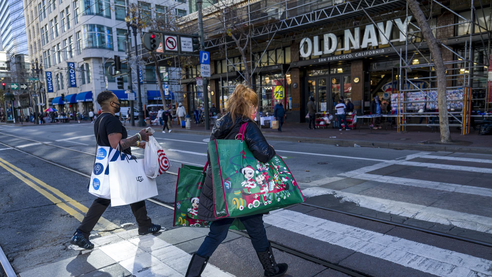 Picture of two people holding shopping bags walking towards an Old Navy