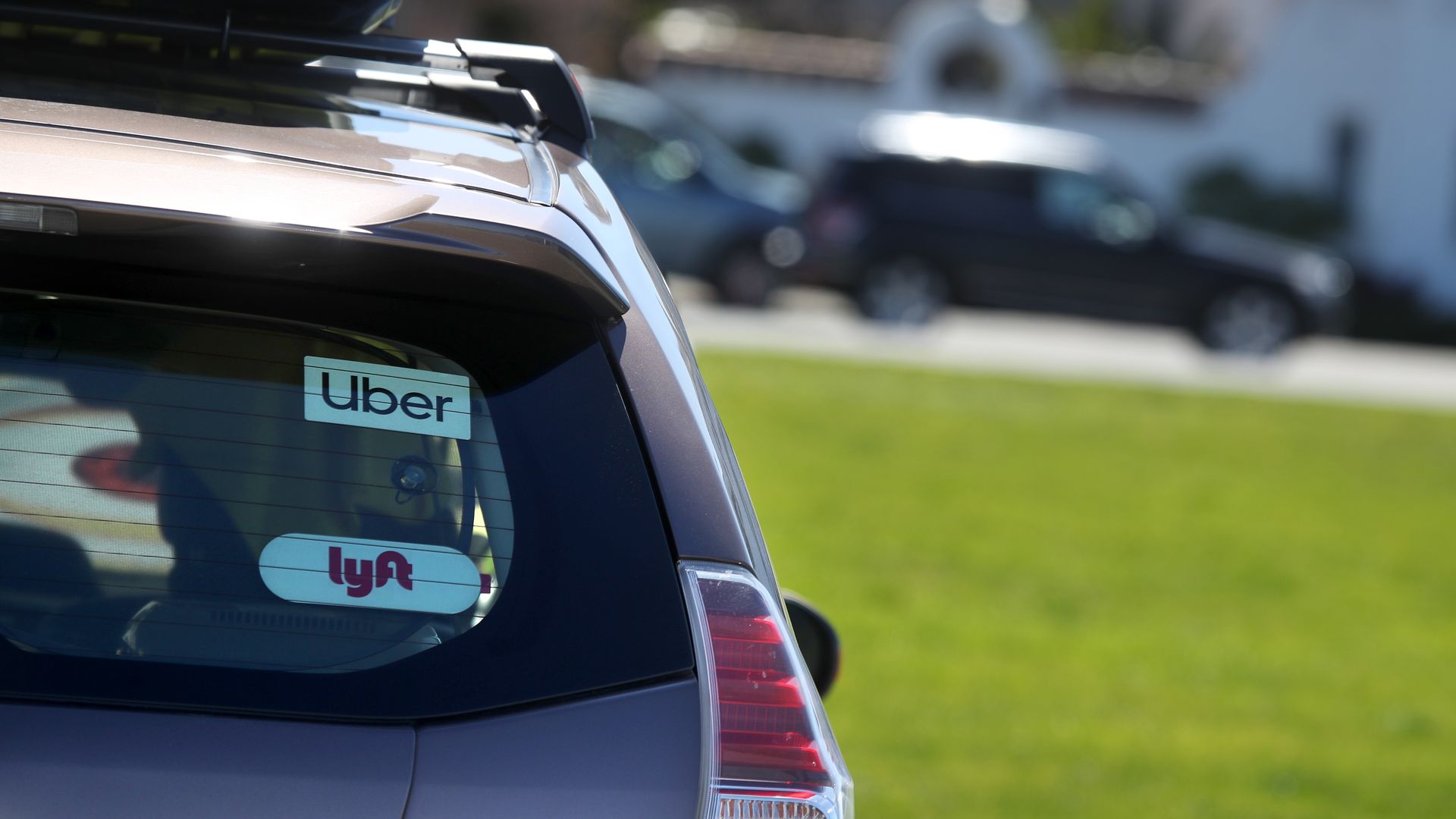 In this image, the back of an SUV car is visible with "Uber" and "Lyft" stickers.