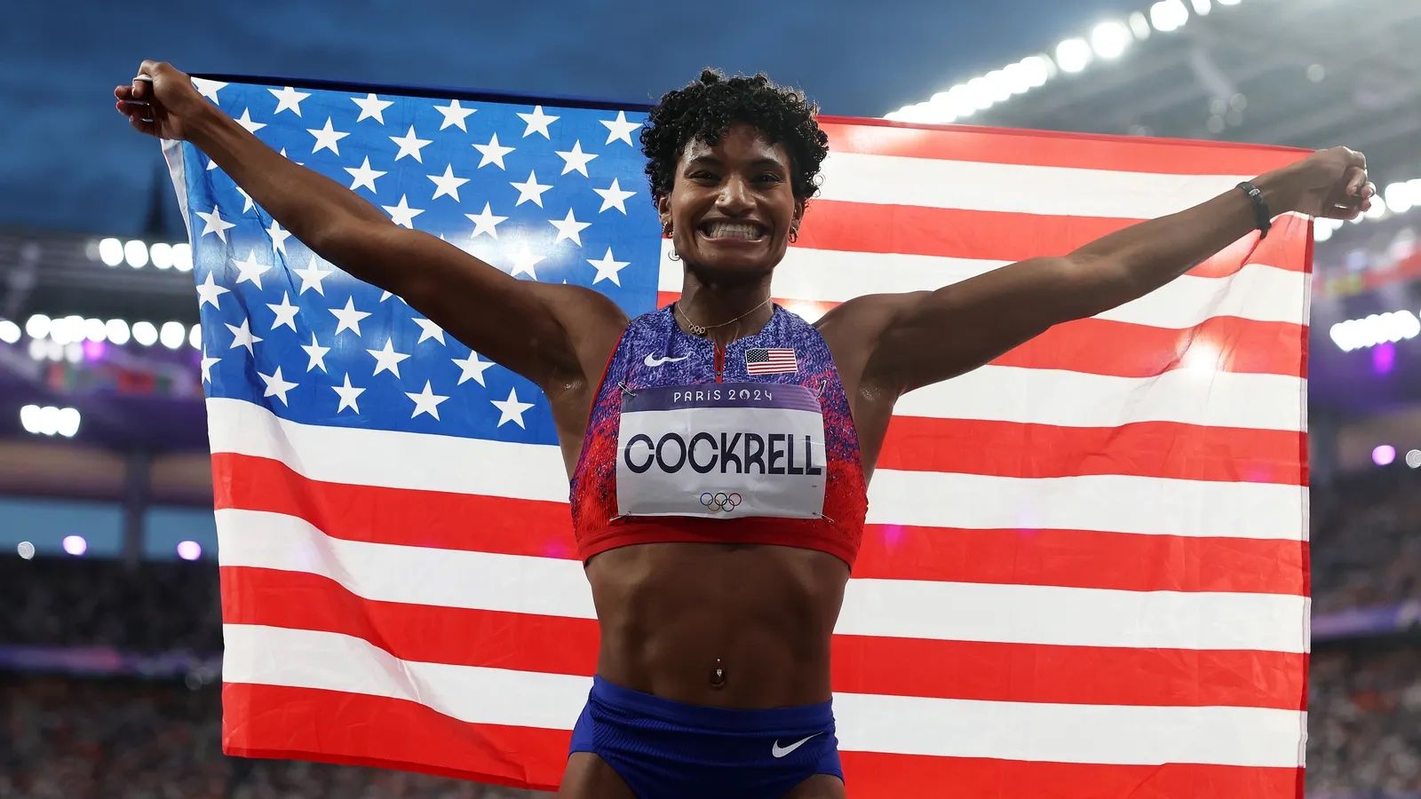 woman holding american flag with arms stretched out