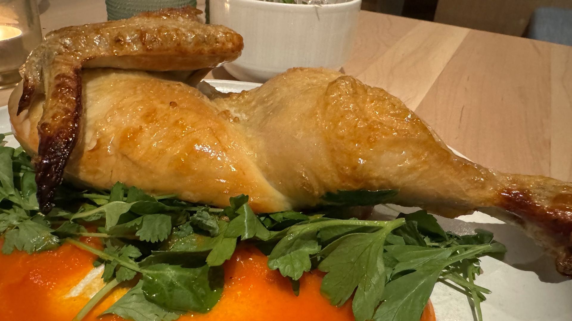 A photo of a roast chicken on a plate. 