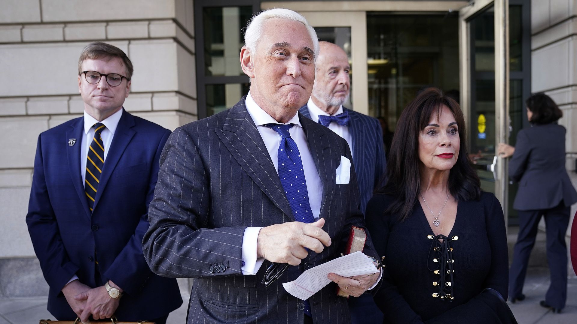 In this image, Stone stands next to his wife and attorney 