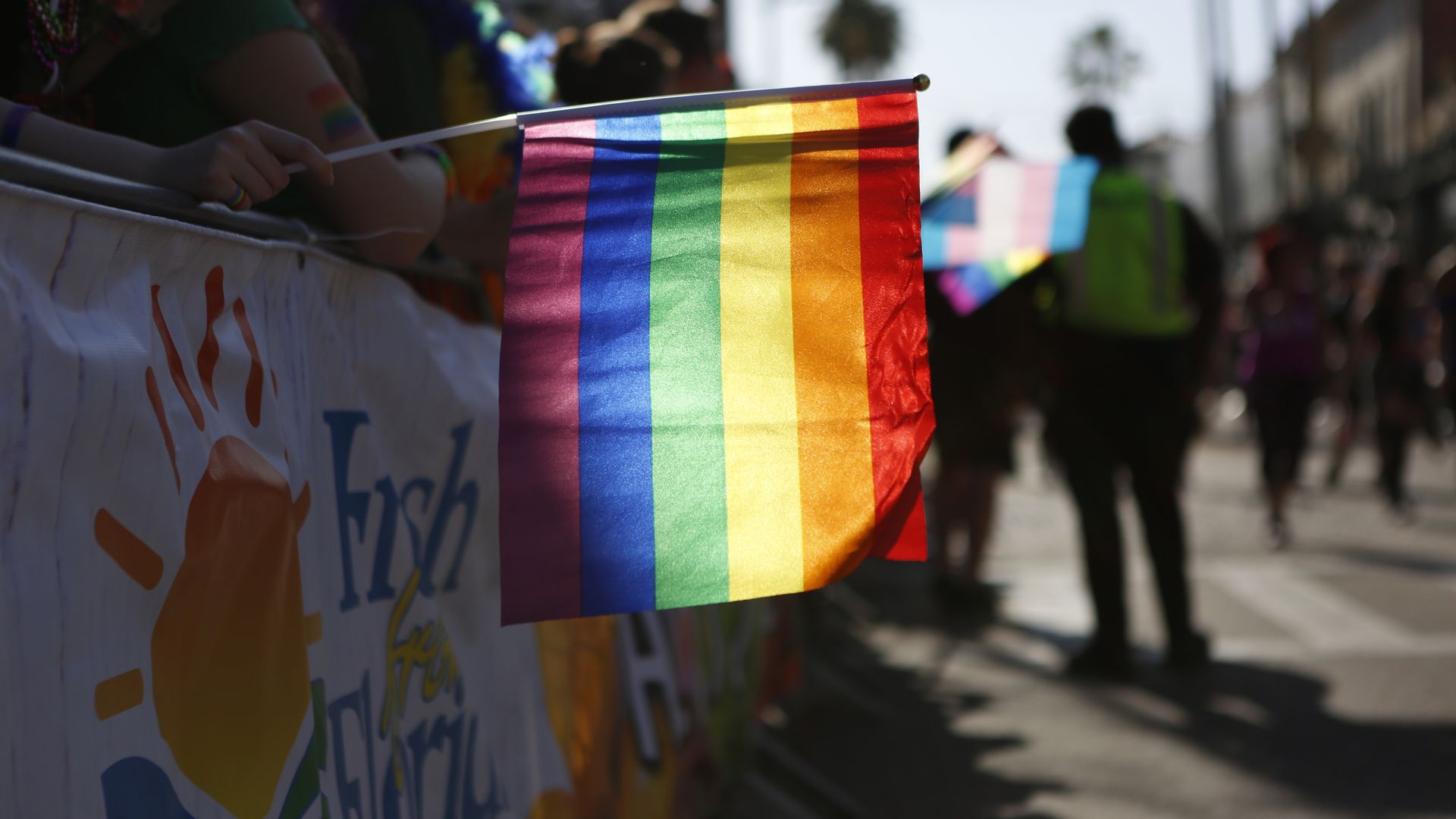 A rainbow flag being held out in the Tampa Pride parade
