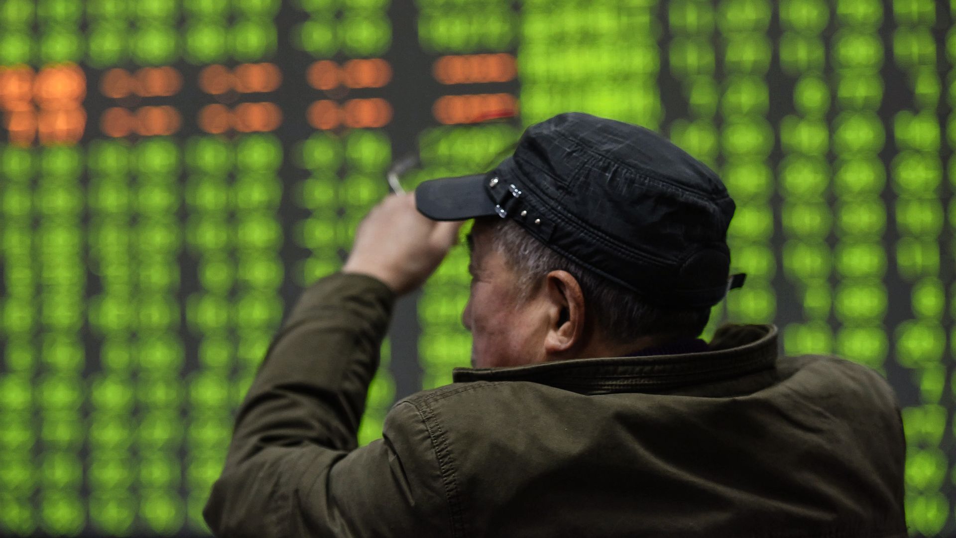 An investor looks at a screen showing stock market movements at a securities company in Hangzhou in China's eastern Zhejiang province on February 3