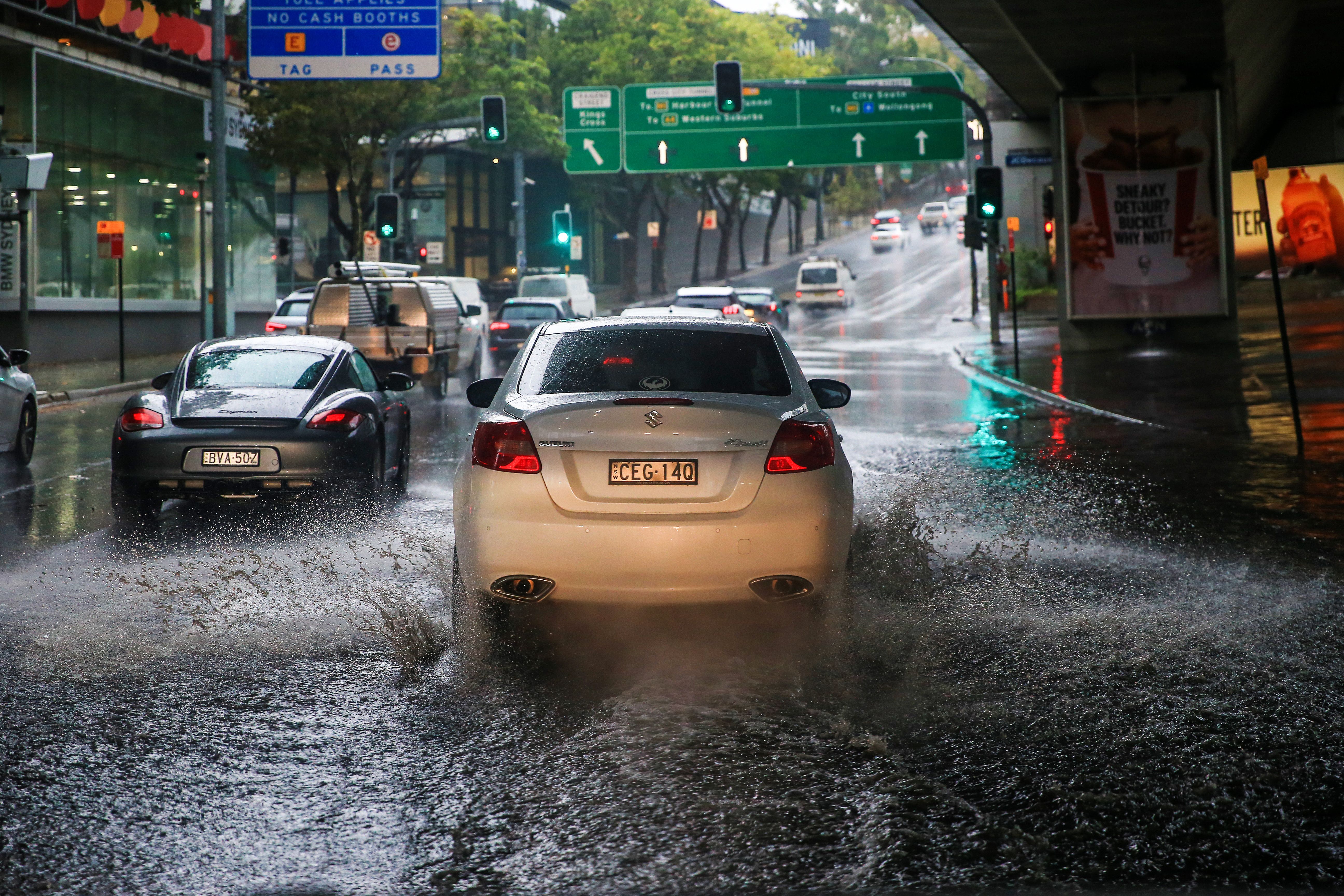 A car is seen traveling through flooded streets in Rushcutters Bay as rain falls on January 17, 2020 in Sydney