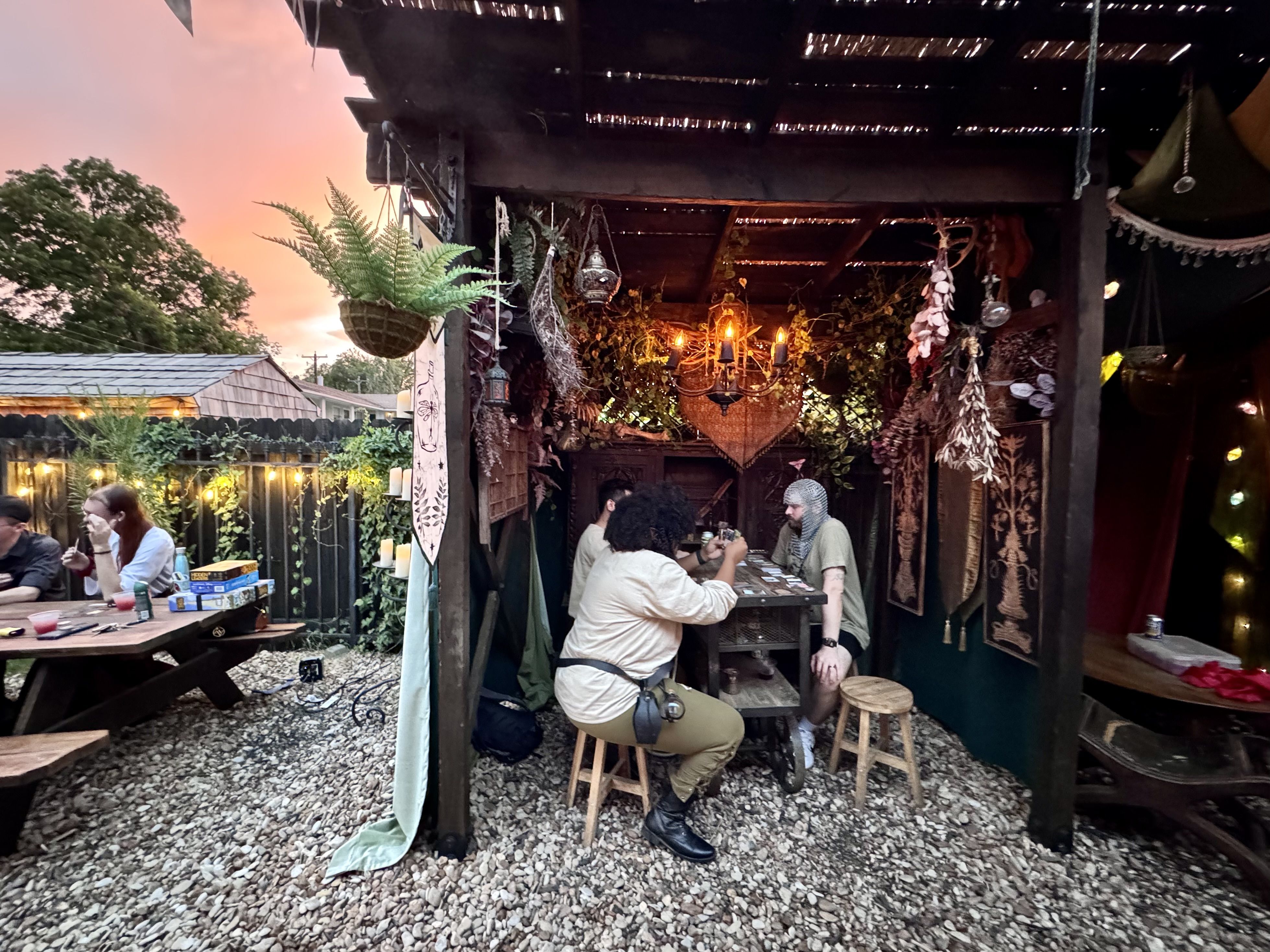 A photo of people seated around a table as the sun sets in the background.