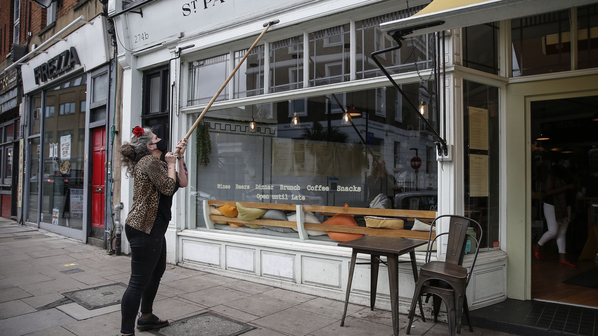 A cafe worker closes awnings in England.
