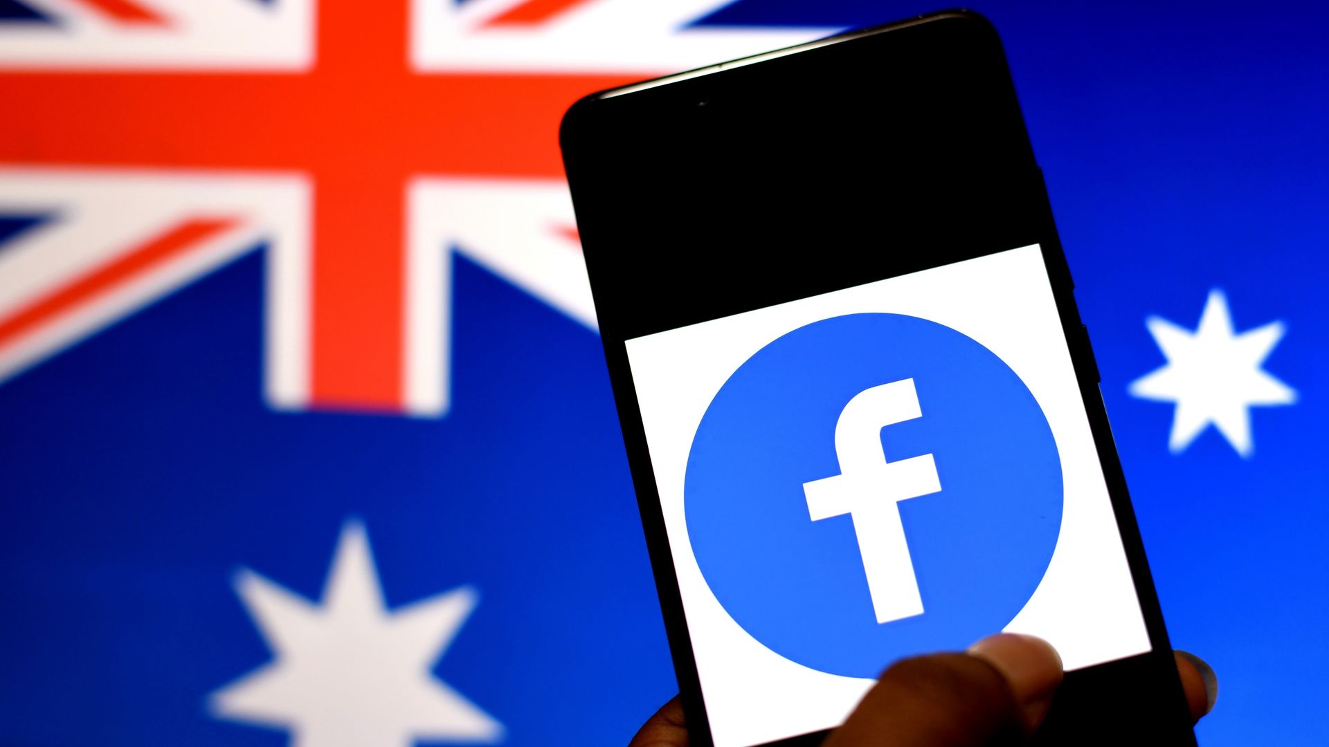 An image of a phone with the Facebook app against the Australian flag