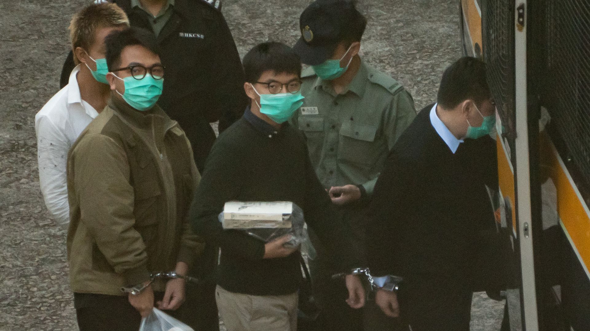 Pro-democracy activists Joshua Wong (C) and Ivan Lam (L) board a Hong Kong Correctional Service van ahead of a sentence hearing at Lai Chi Kok Reception Centre on December 2, 2020 in Hong Kong