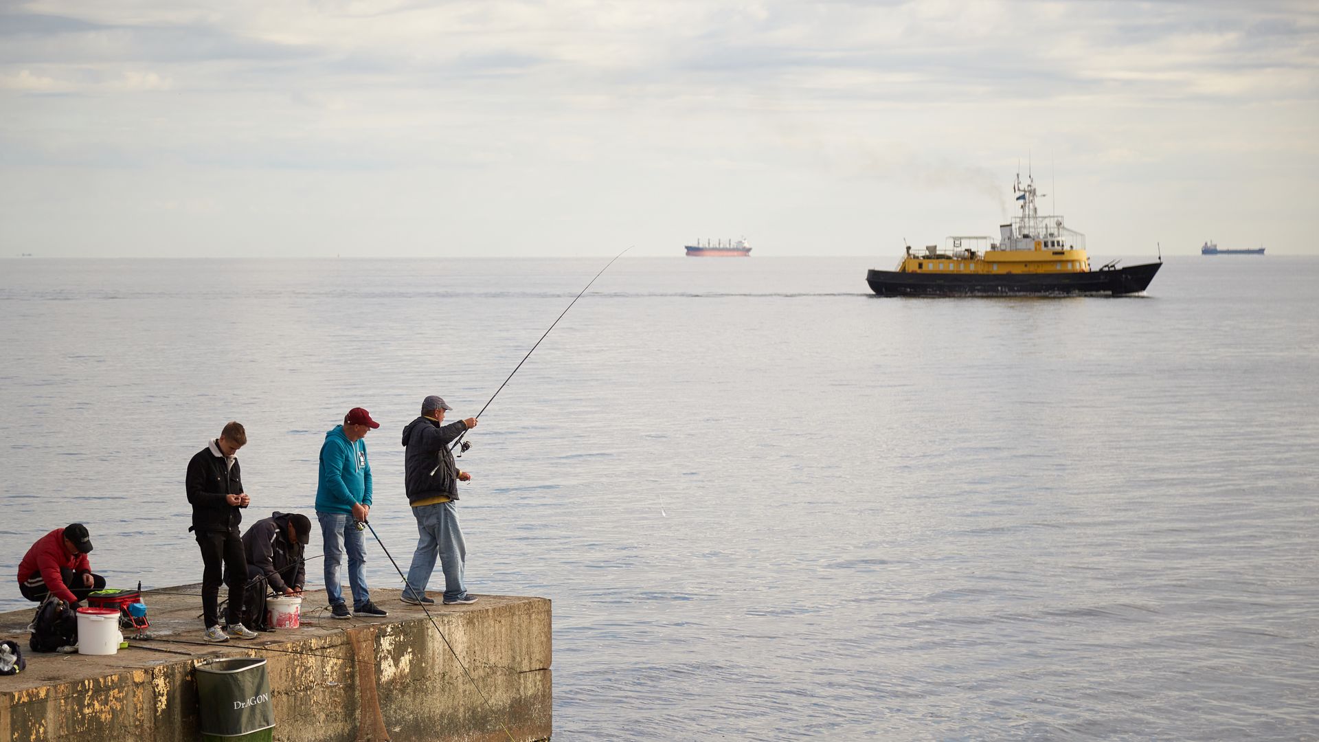 One man holds fishing pole while other four prepare near the Black Sea