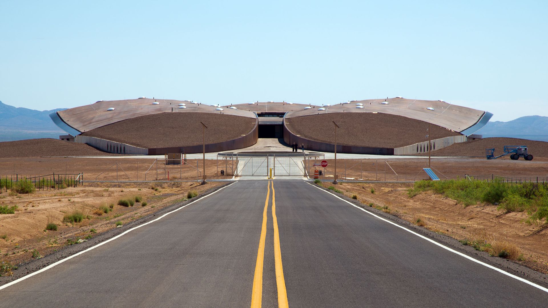 In this image, Spaceport America is seen at the end of a long desert road. It looks like a large drone.