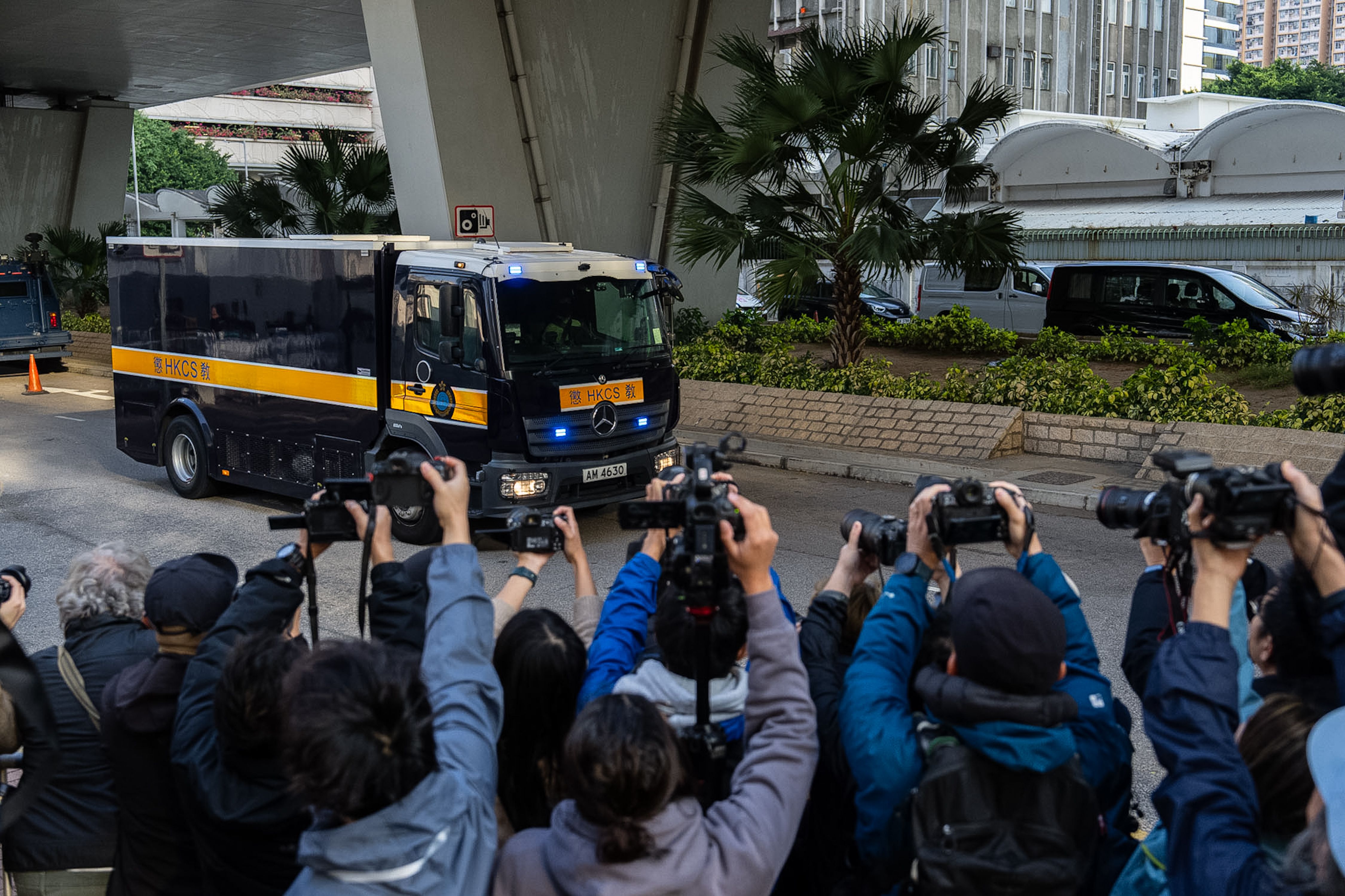 Press photographers take pictures of a corrections vehicle believed to be carrying Jimmy Lai in Hong Kong this morning.