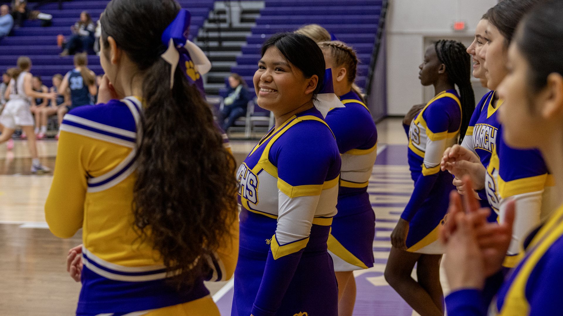 Denison cheerleaders hang out by the side of the high school gym
