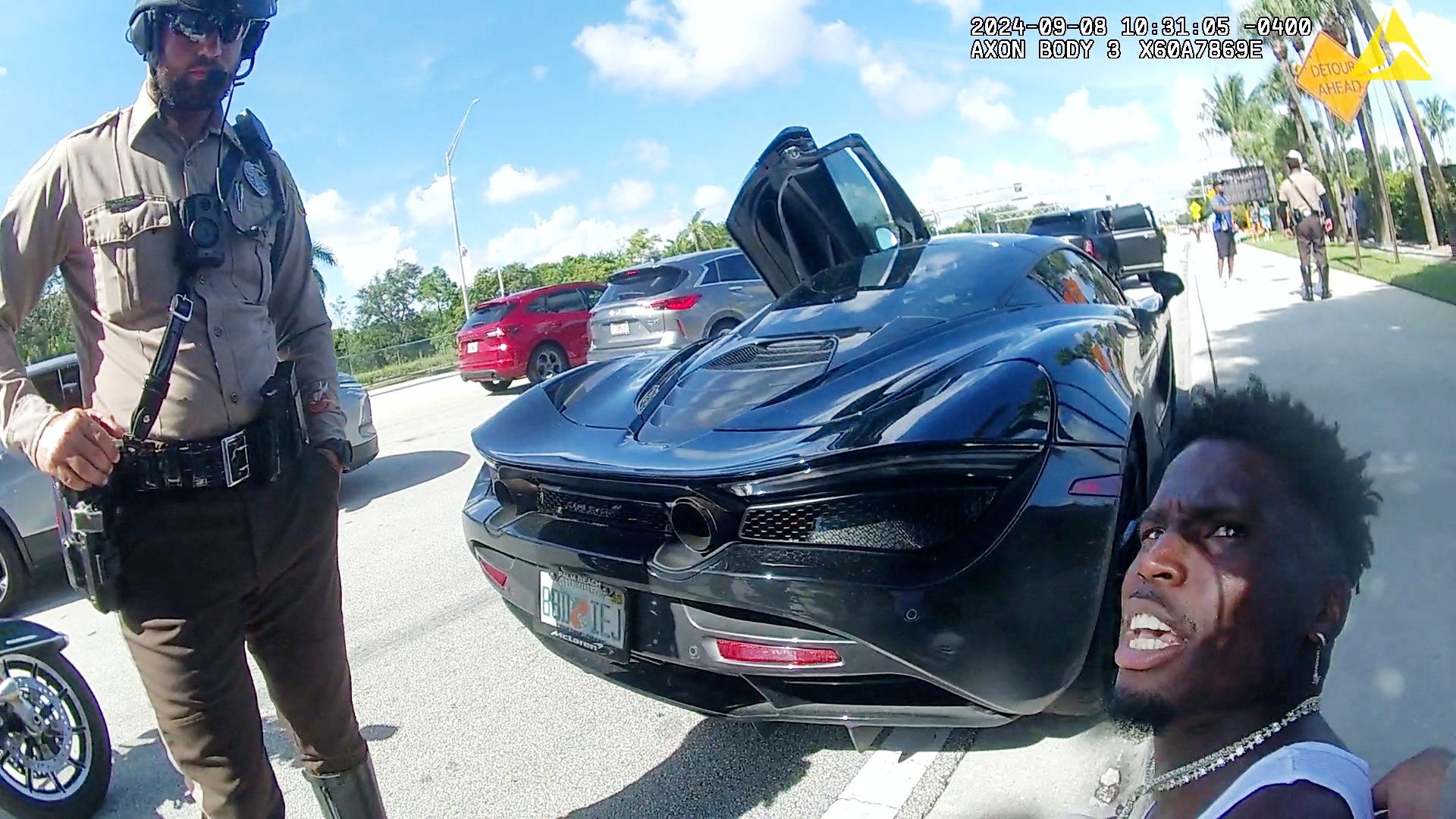 Miami Dolphins receiver Tyreek Hill sits on the ground after being handcuffed by Miami-Dade Police Department officers in Miami, Florida, September 8, 2024 in a still image from police body camera video