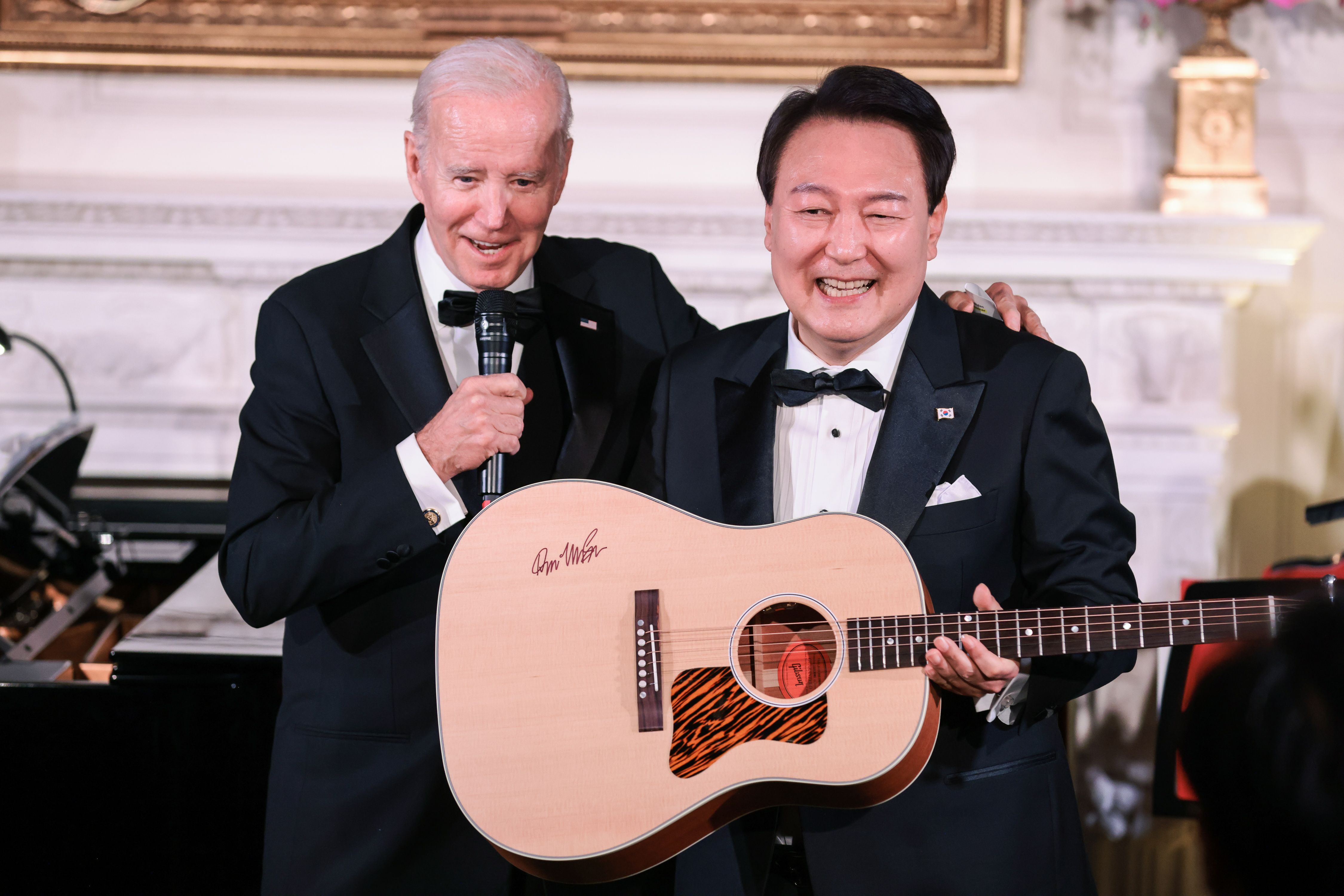 Yoon receiving a guitar from Biden