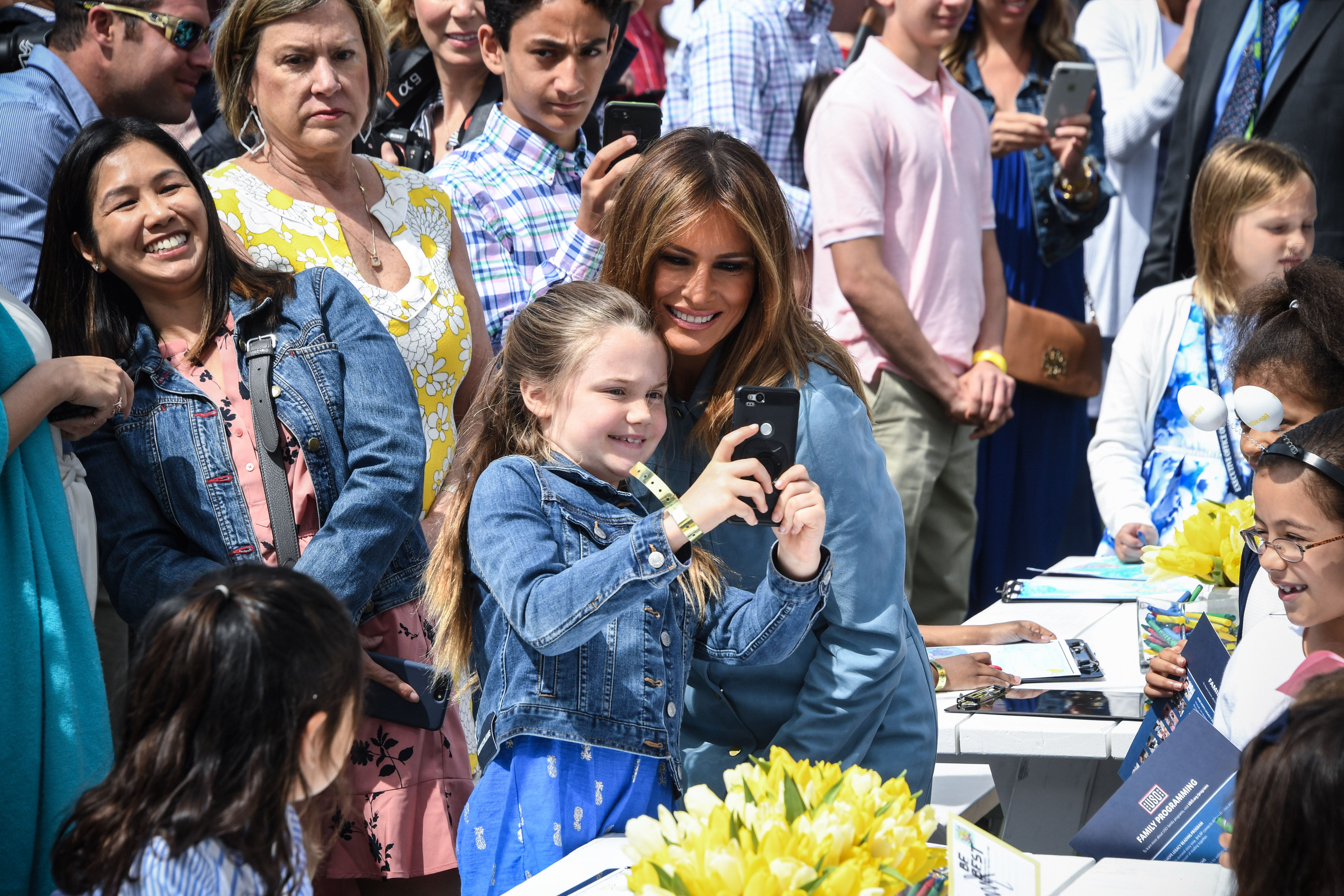 Melania Trump poses with a child for a selfie.