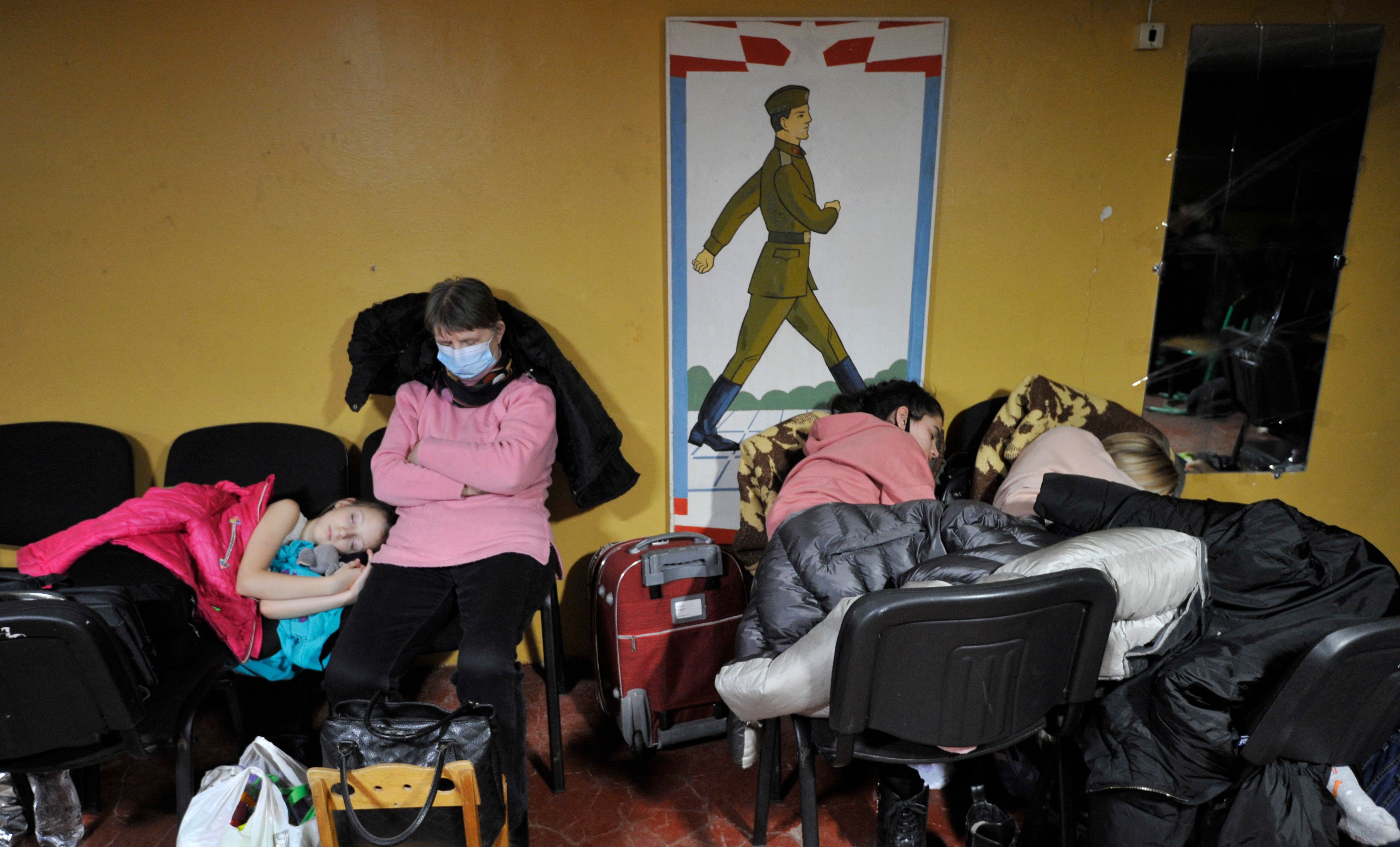 People hide in a bomb shelter in Kyiv in the early hours of February 25.