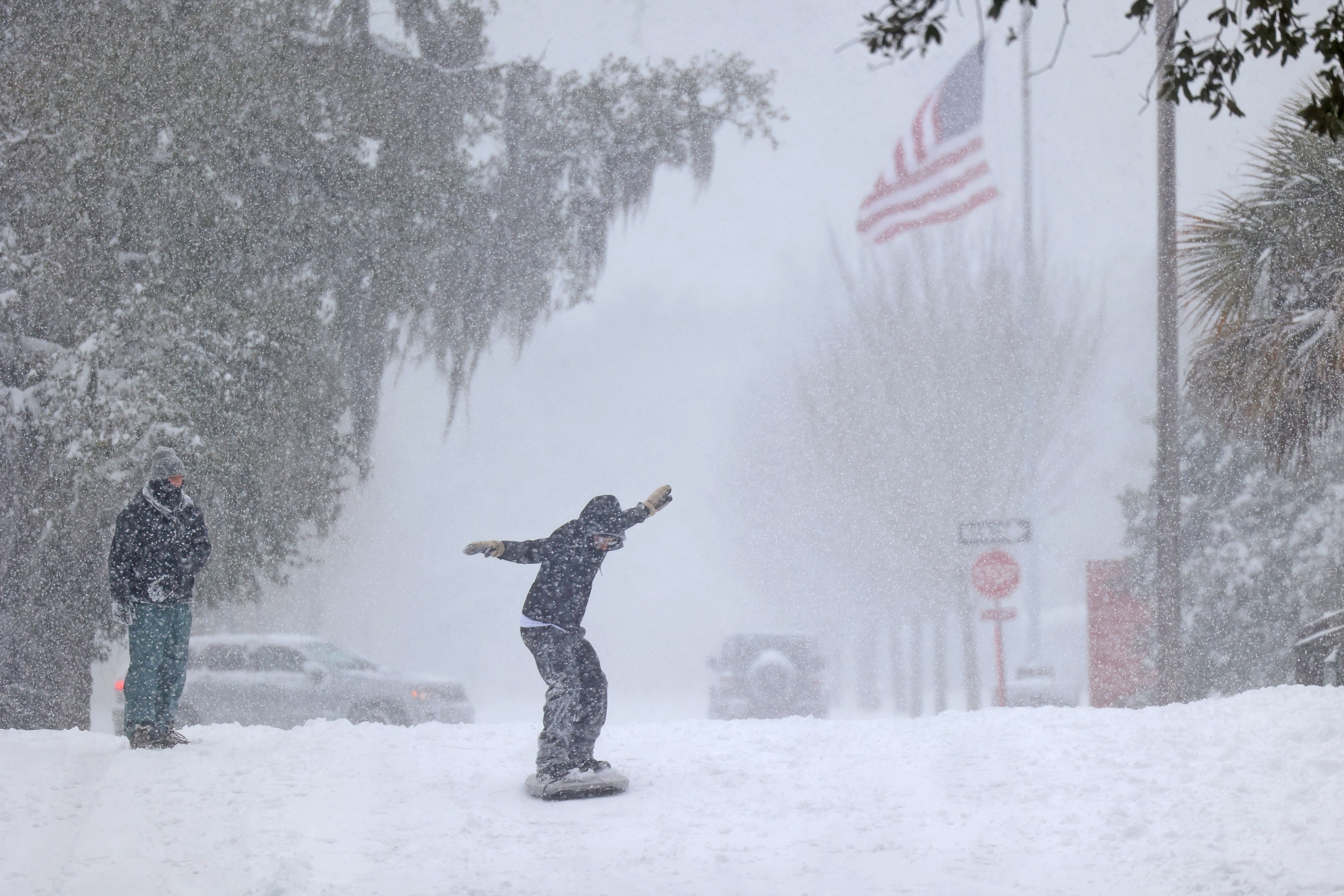 Photo shows a person snowboarding through City Park.