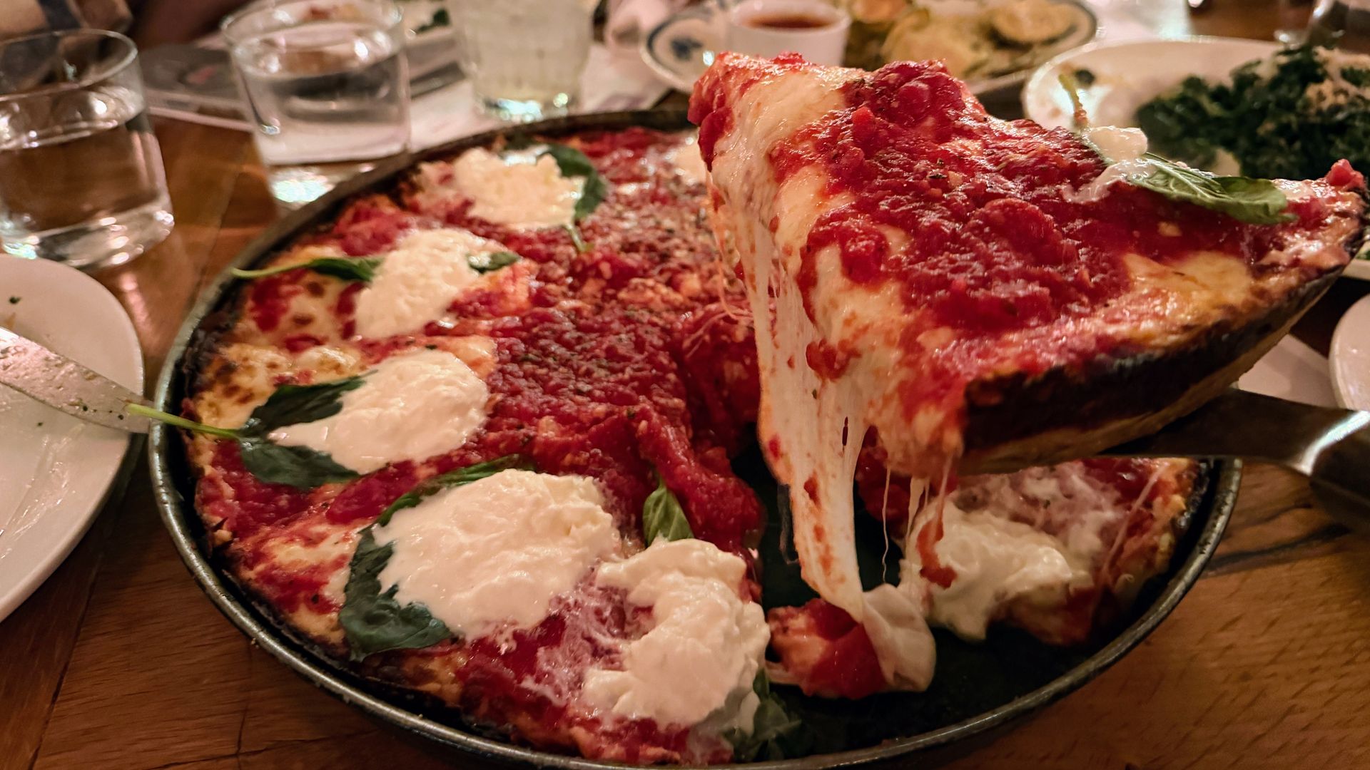 A spatula picks up a big heavy piece of pizza