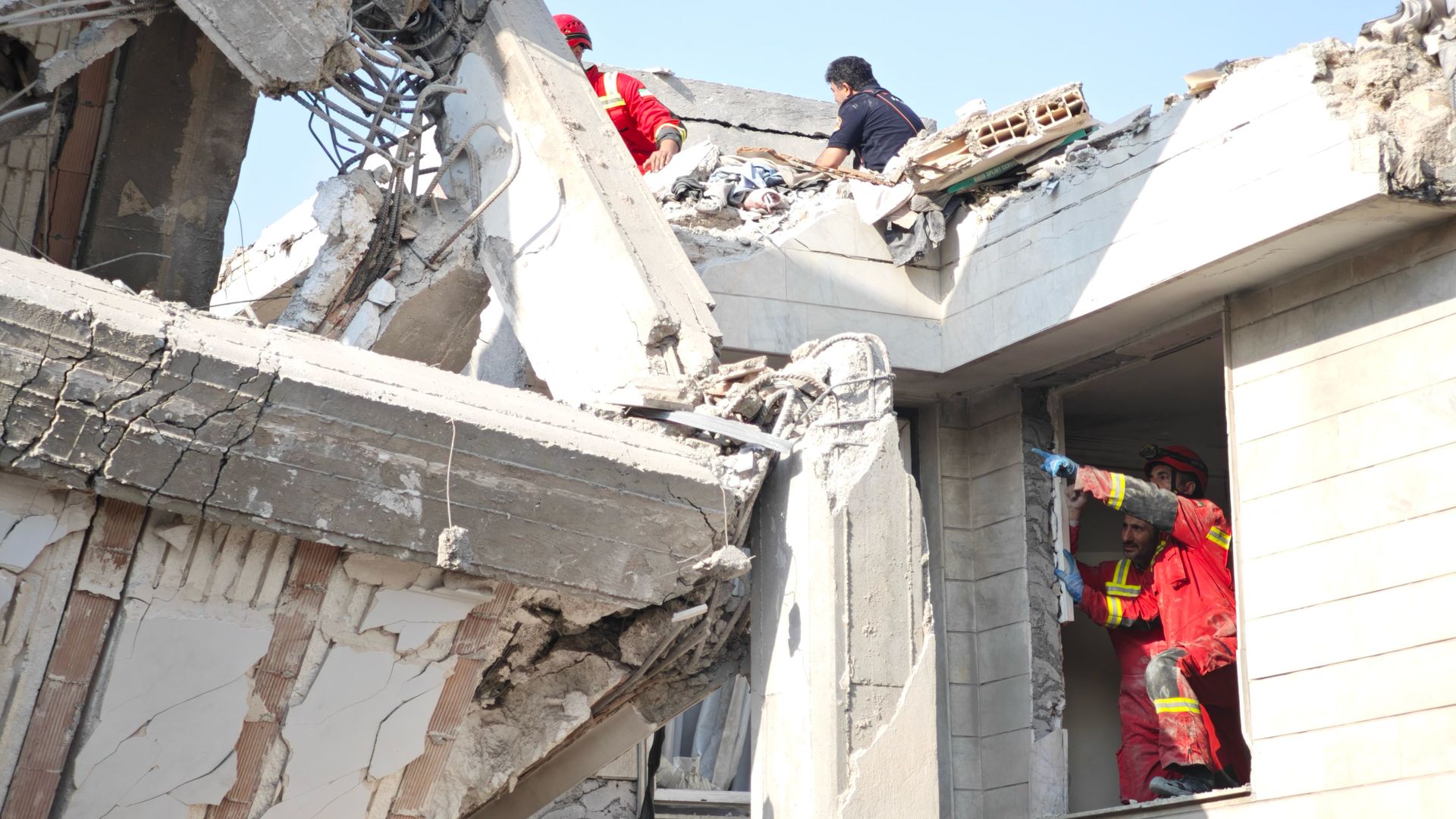 People assess damage to a building that was struck 