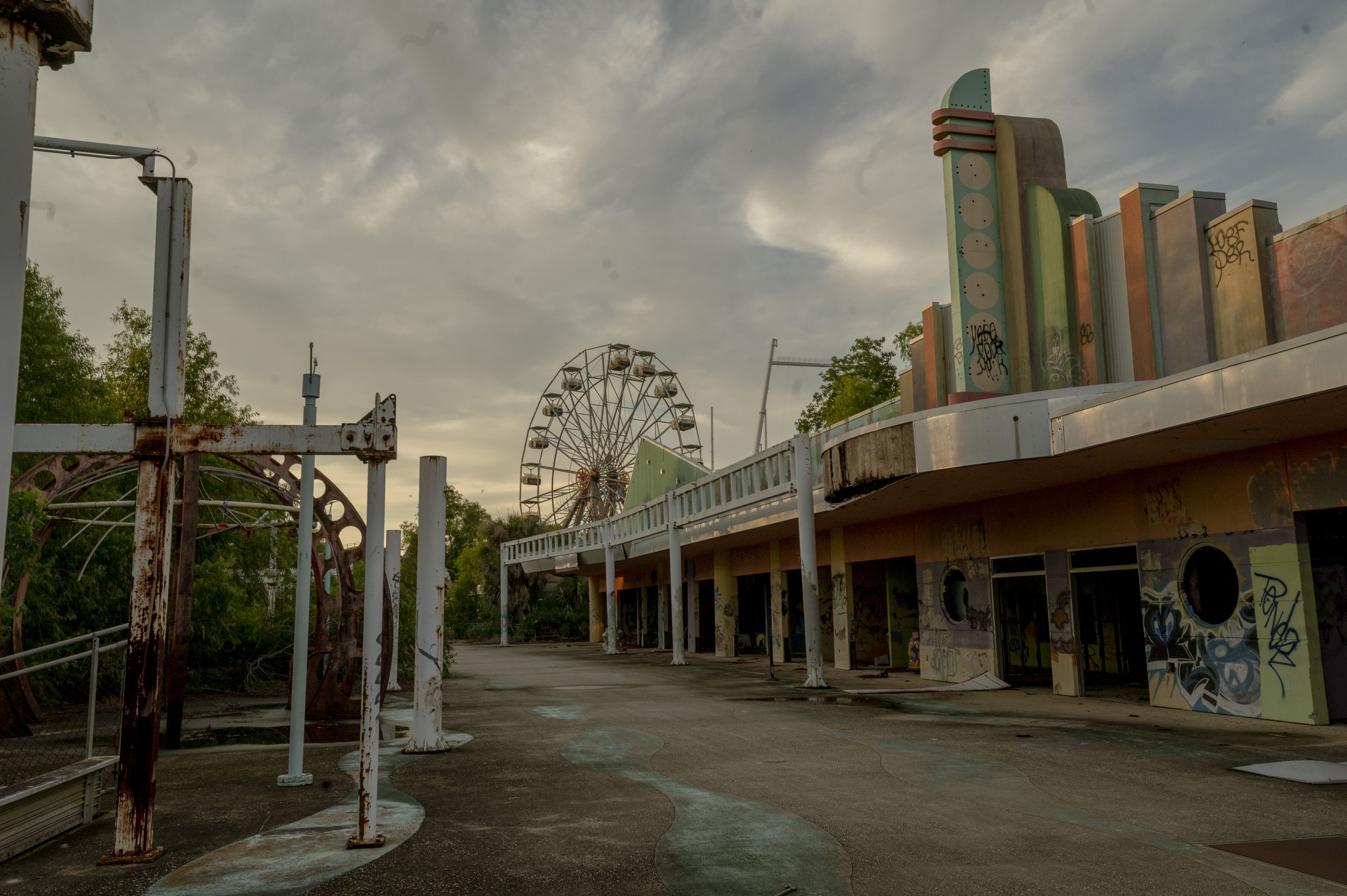 Image shows a ferris wheel and other abandoned buildings at Six Flags in New Orleans.