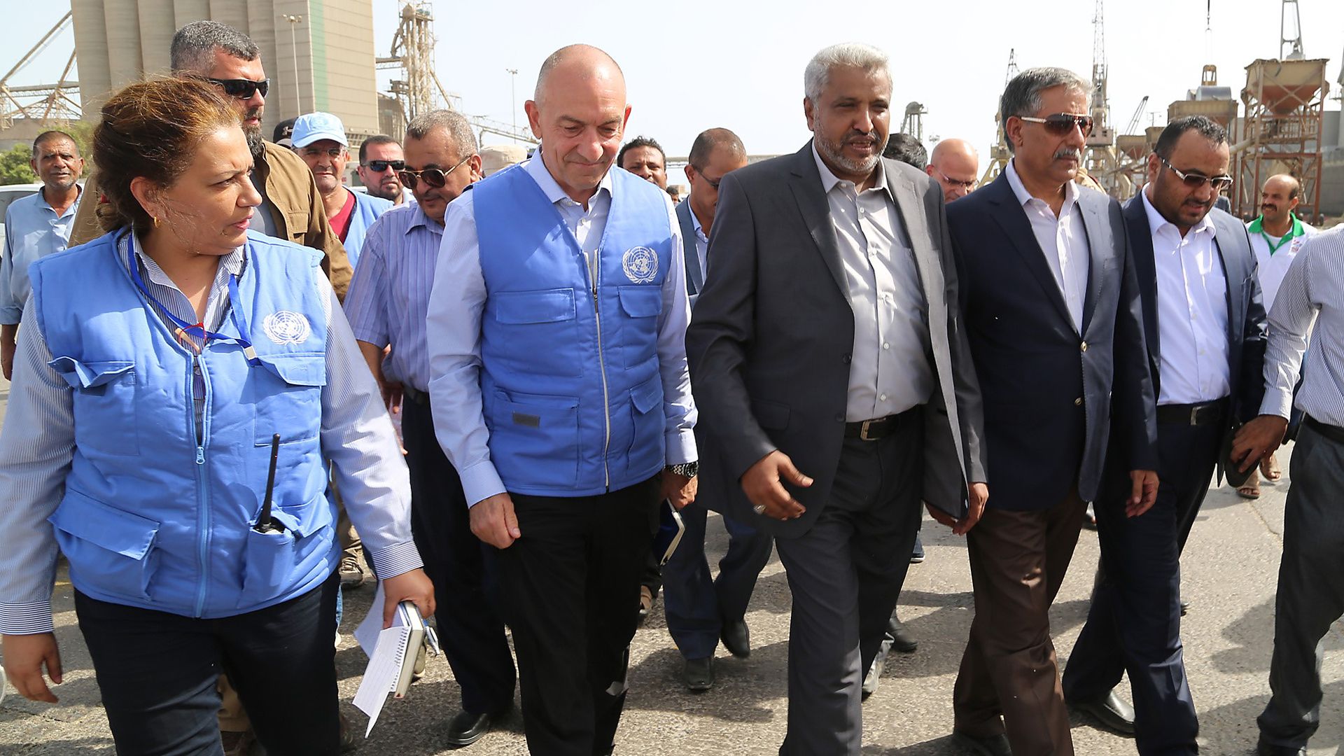 UN peacekeepers and acting governor of Hodeidah walking near port