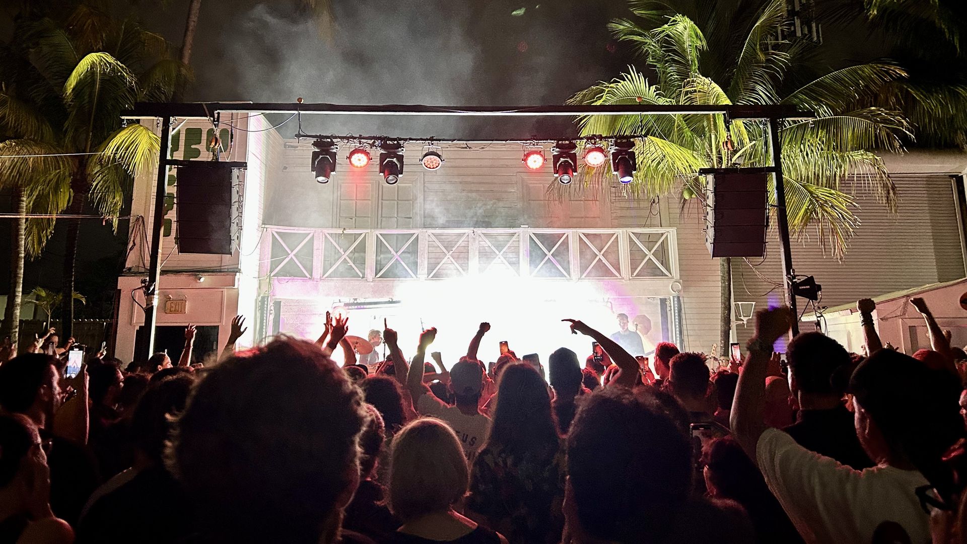 A group of people in front of a lit up stage.