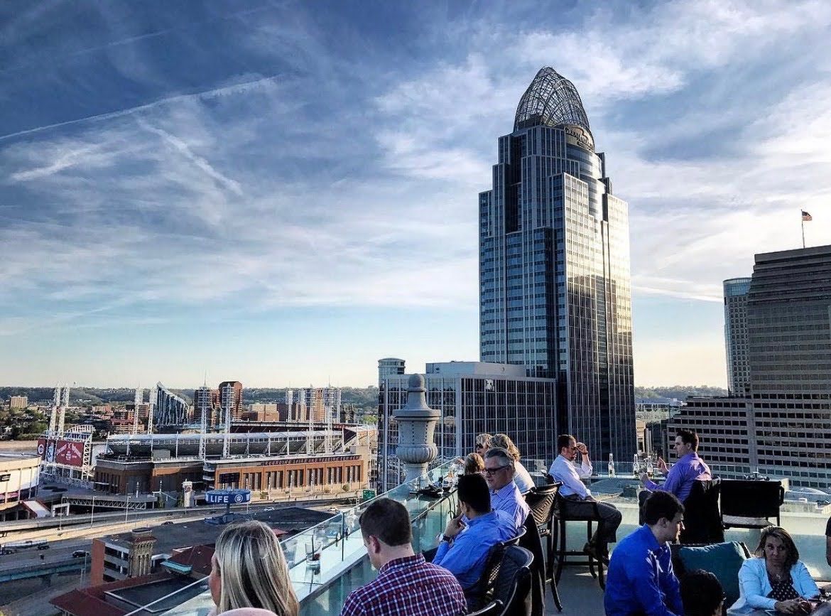 A photo of a crowded rooftop bar in downtown Cincinnati overlooking Great American Ball Park and Great American Insurance. 