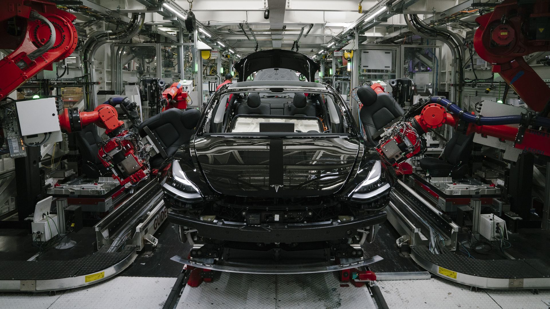 Robotics arms install the front seats to the Tesla Model 3 at the Tesla factory in Fremont, California, on Thursday, July 26, 2018.