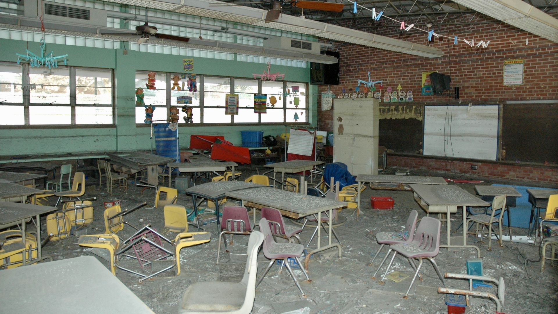 Photo shows a dirty classroom with chairs knocked over and grime everywhere
