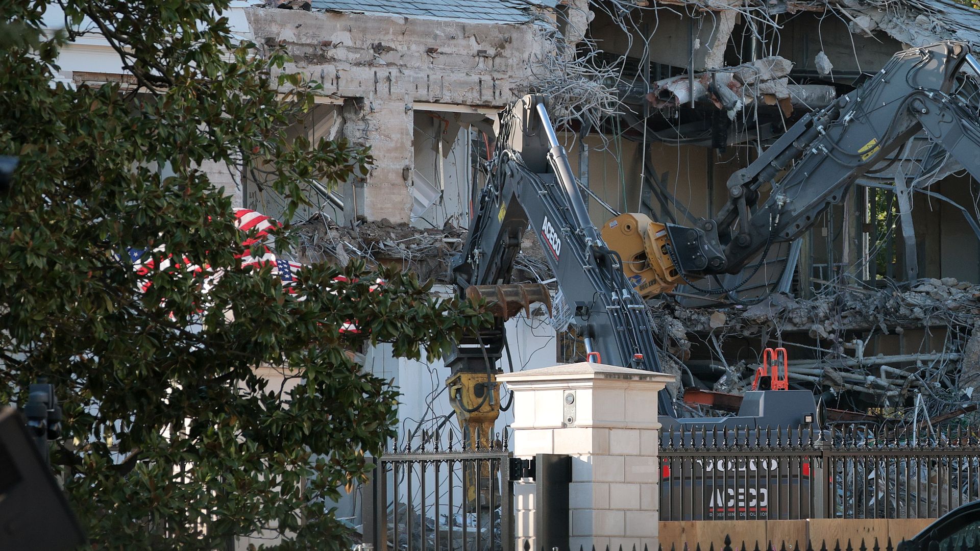 A photo showing a construction vehicle demolishing the exterior of the White House's East Wing.