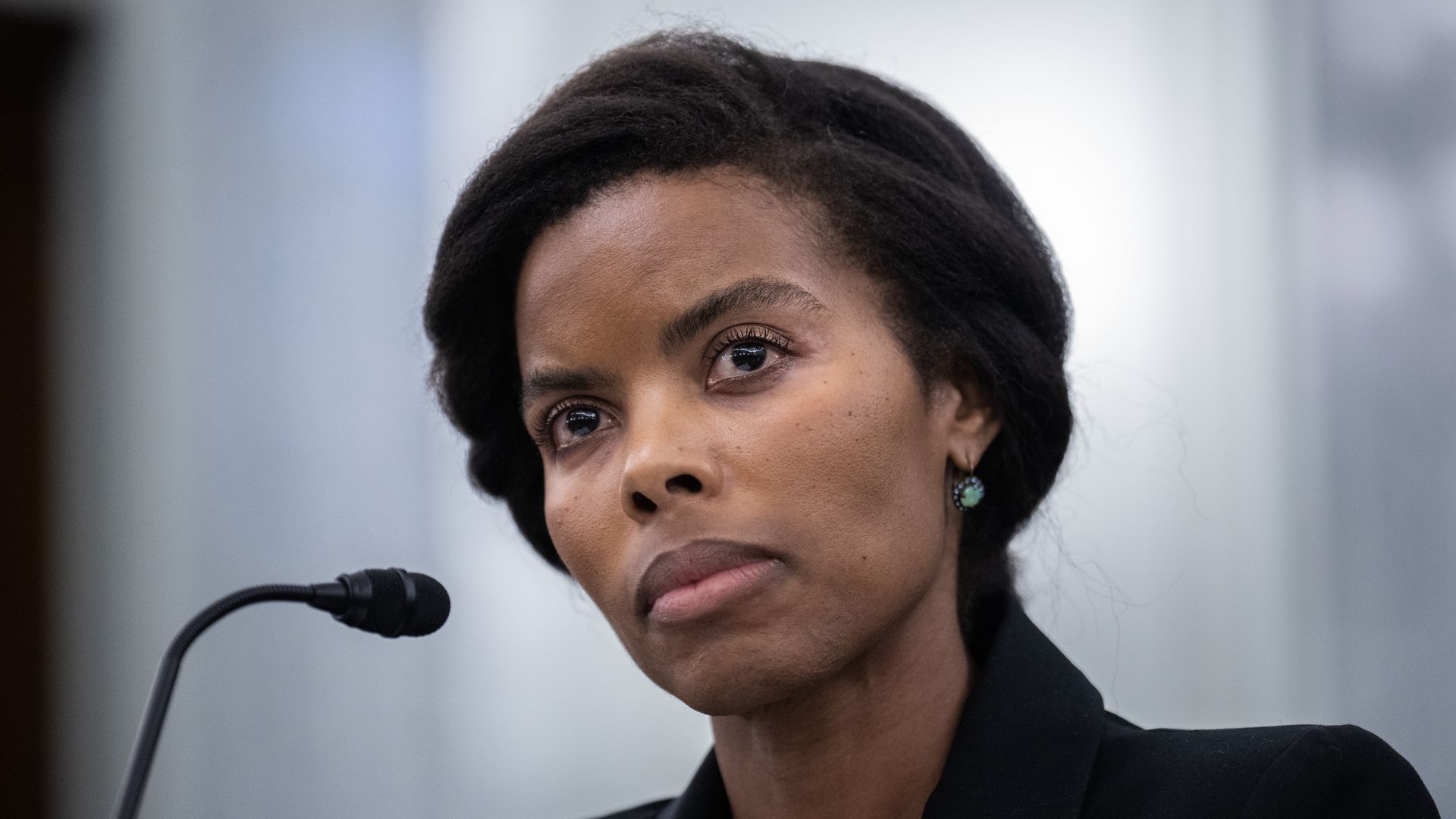 A person tilts their head in front of a microphone