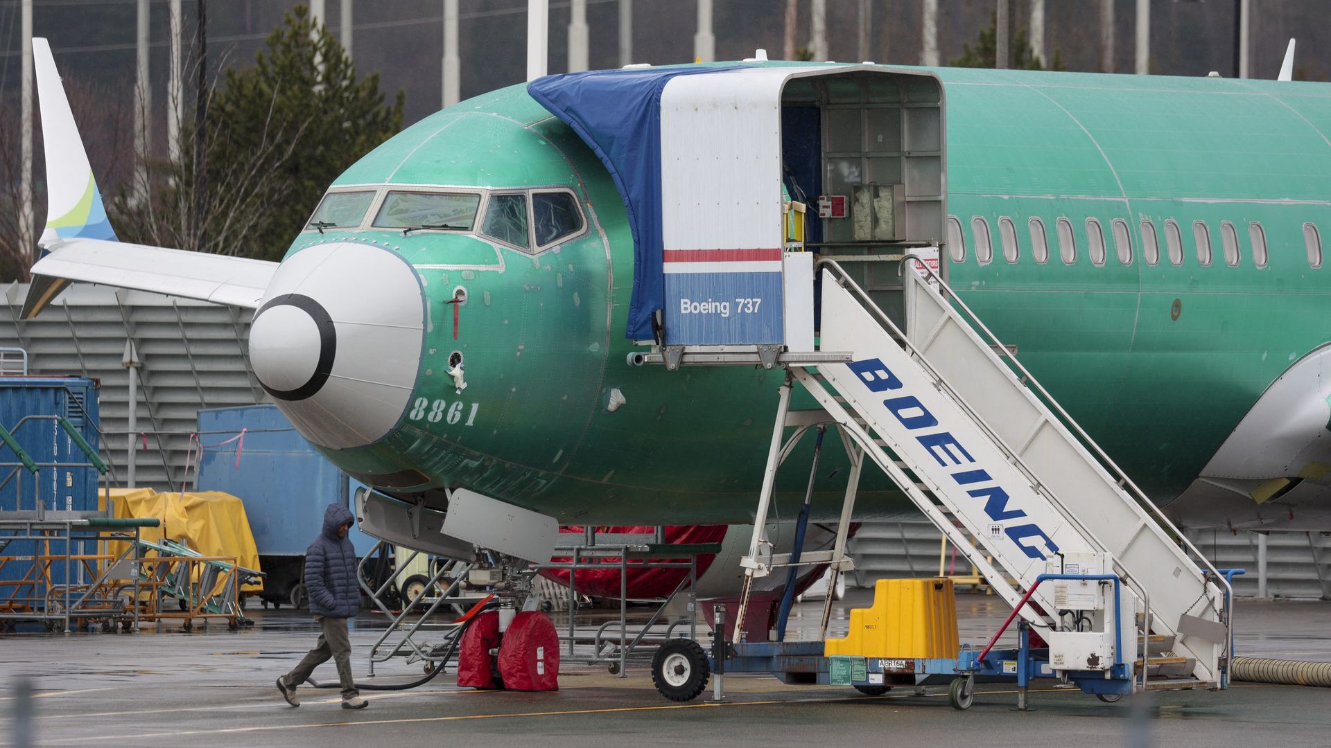 A person walks past an unpainted Boeing 737-8 MAX parked at Renton Municipal Airport adjacent to Boeing's factory in Renton, Washington on January 25, 2024. 