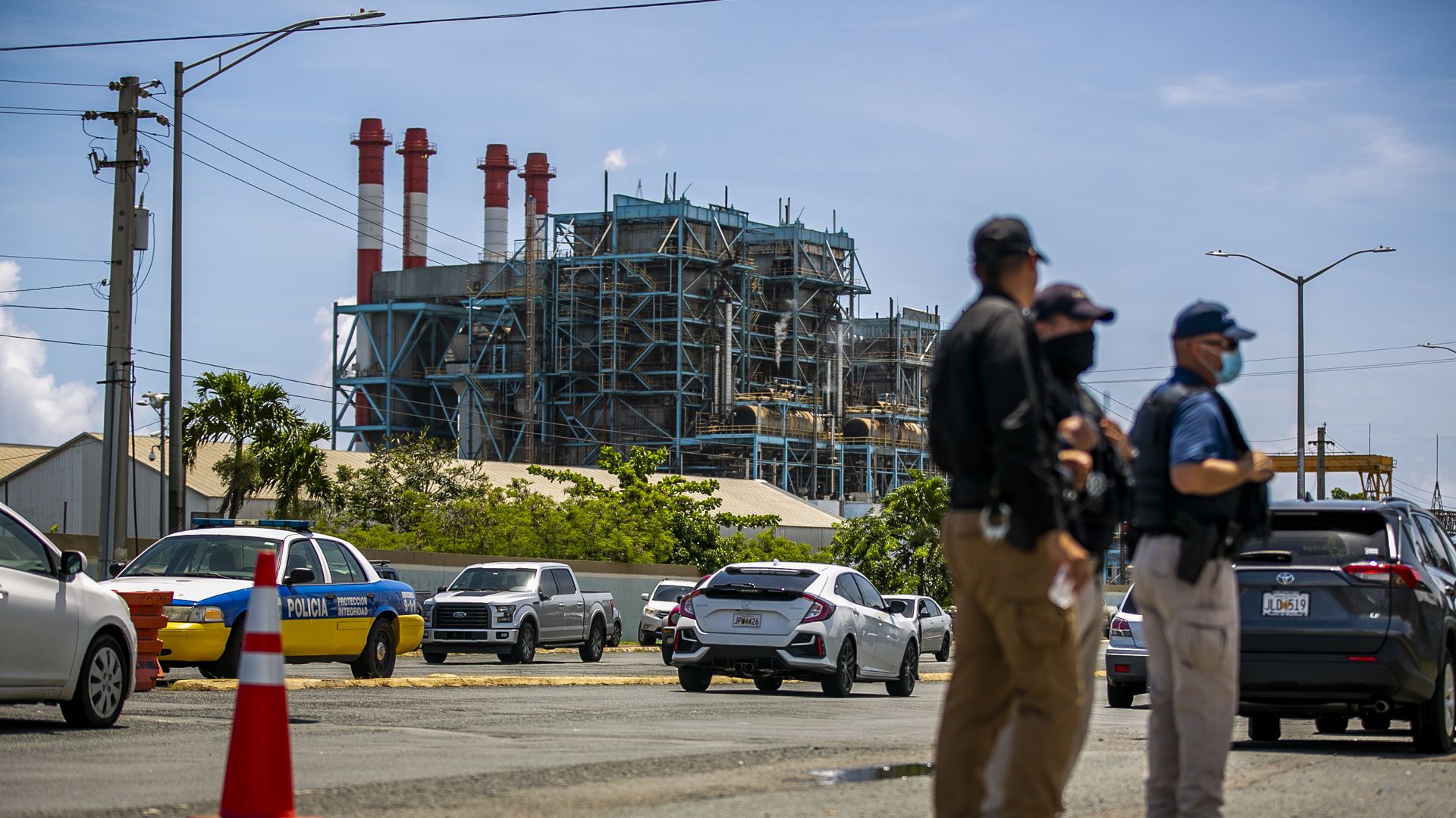 Photo of a Luma Energy power plant with three people standing in the foreground
