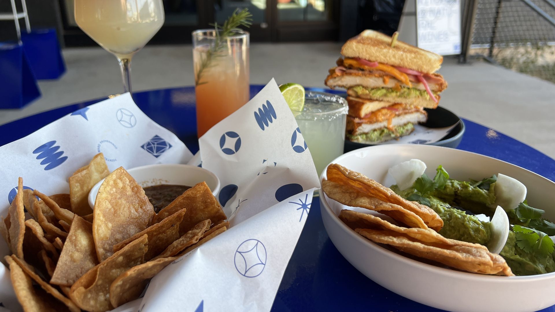 several dishes, dips and drinks on a patio table