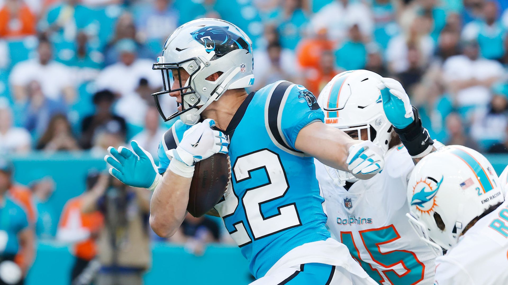 Christian McCaffrey running away on the field with football in hand