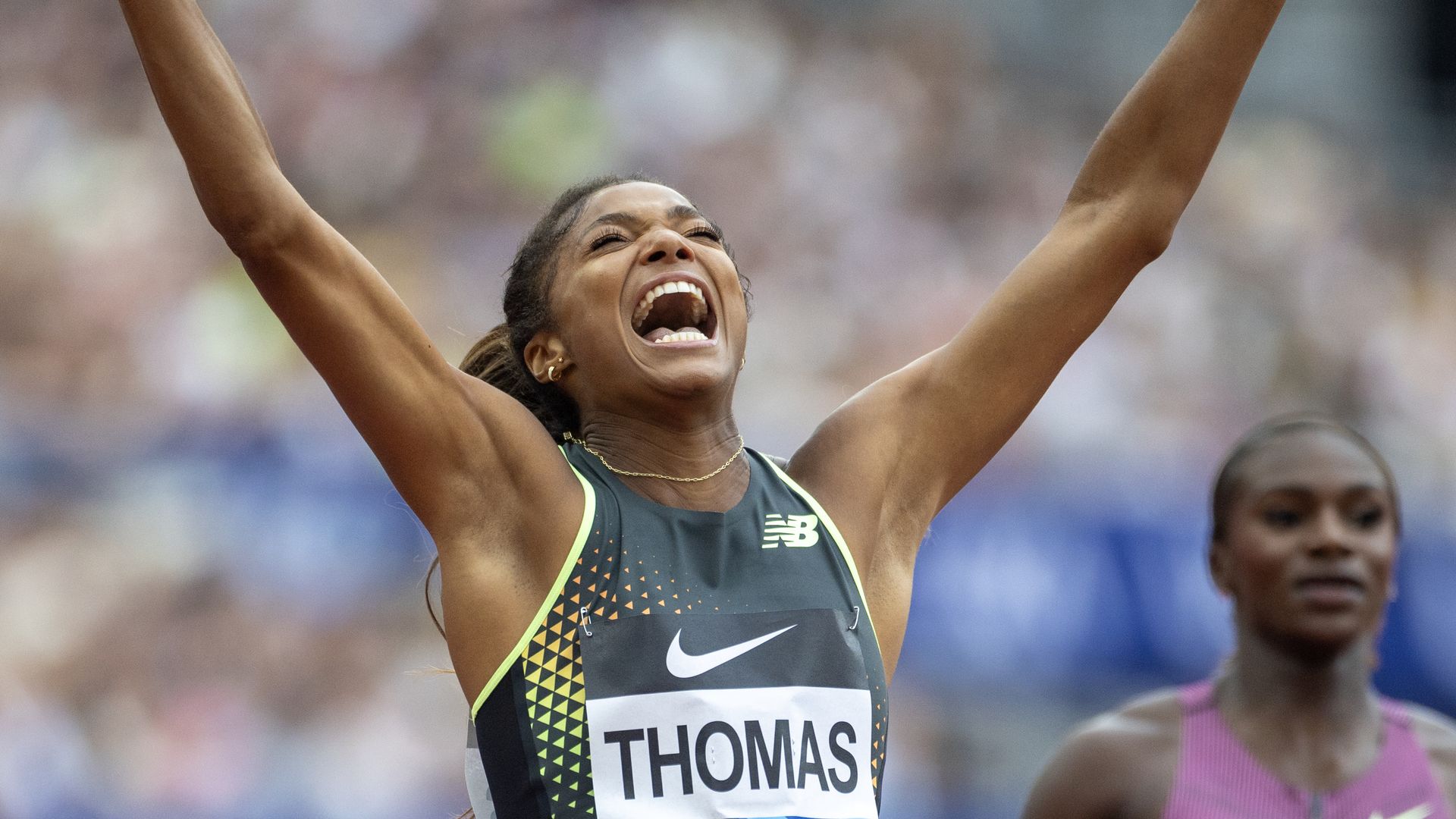 Gabrielle Thomas throws her hands in the air after the 200m event.