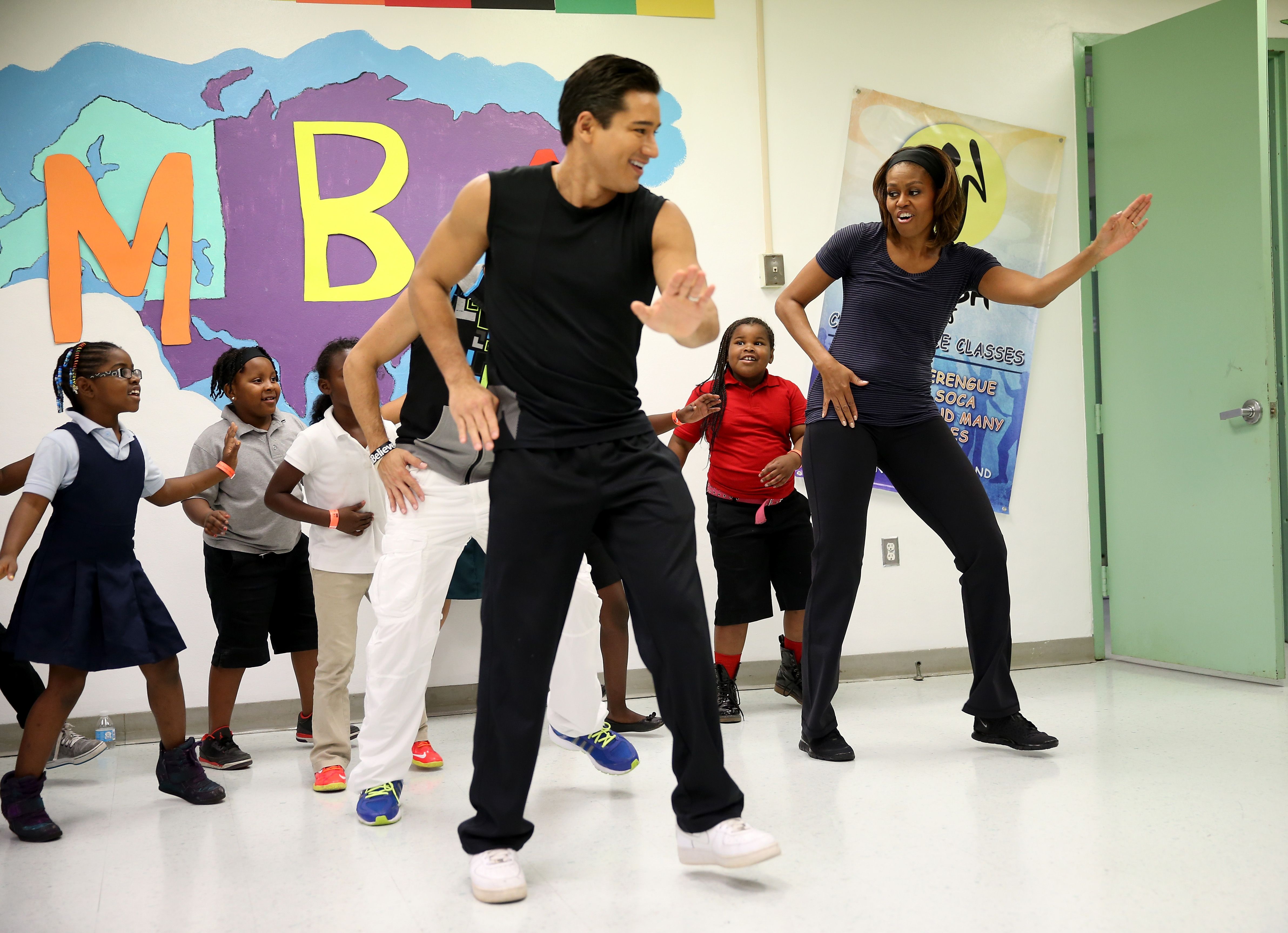 First Lady Michelle Obama dances with Mario Lopez in a Zumba class with Miami children at Gwen Cherry Park NFL/YET Center in 2014. Photo: Larry Marano/WireImage