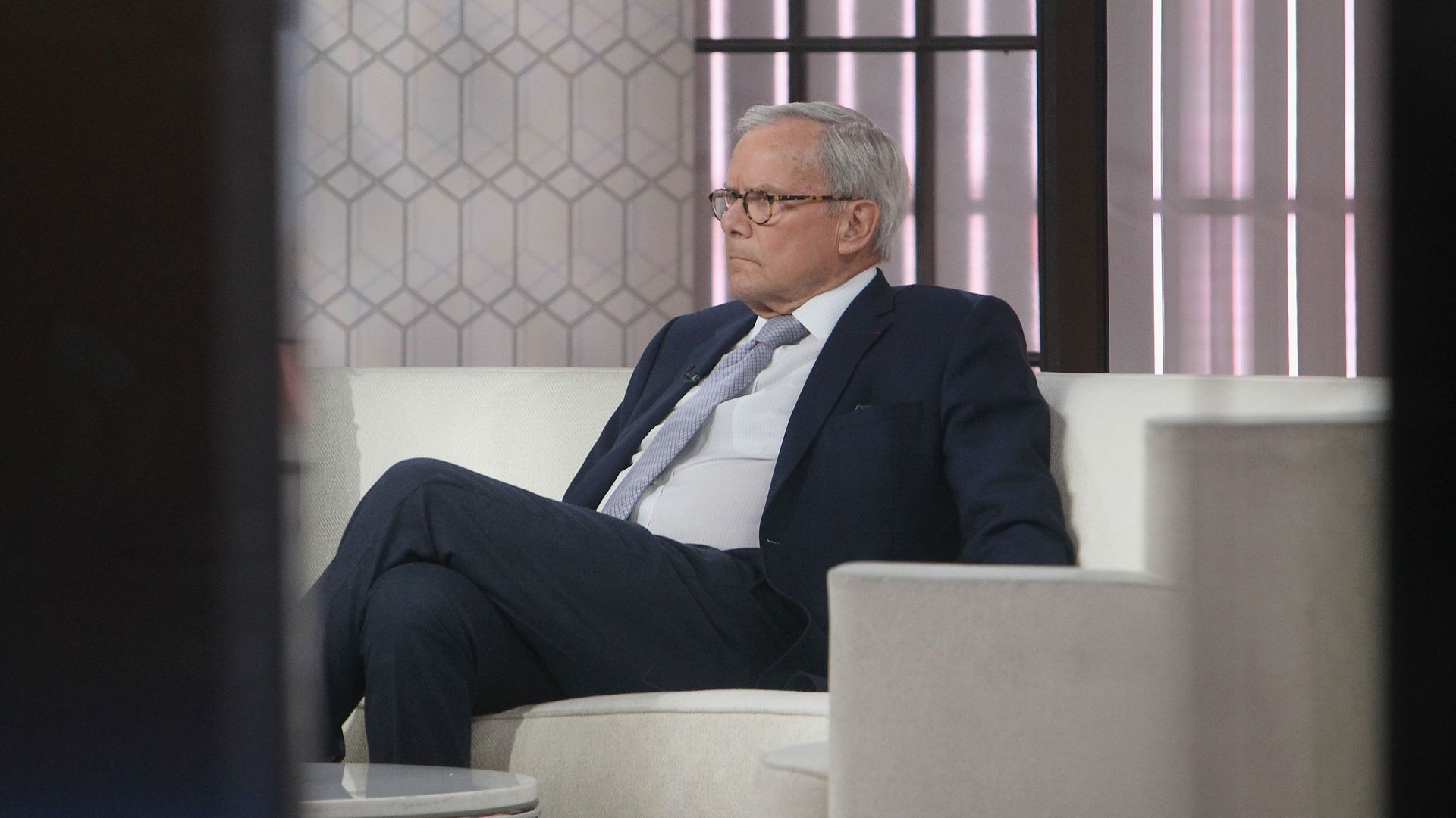 Tom Brokaw sitting on a couch.